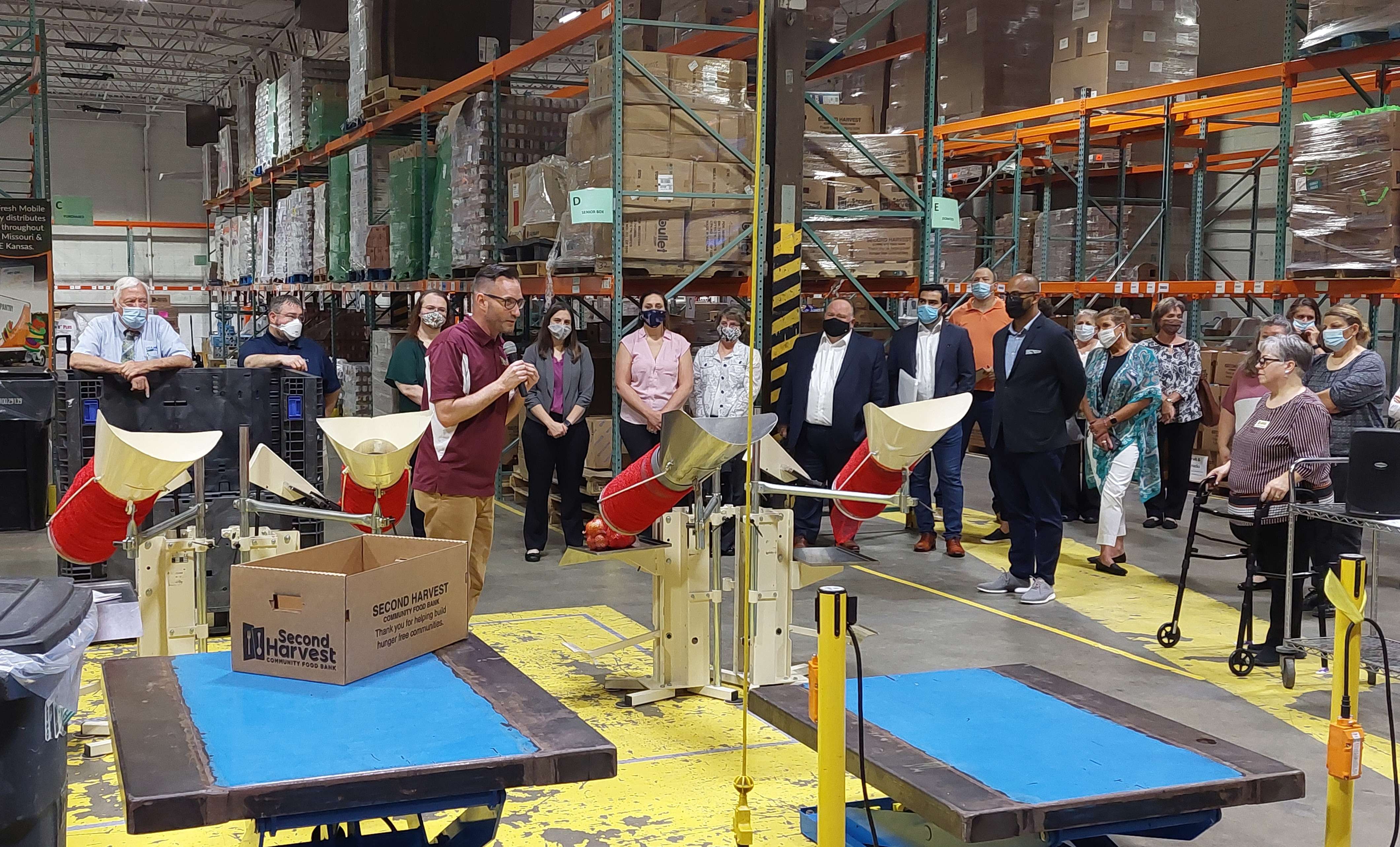 Joaquin Altoro and a crowd look on as a Second Harvest official displays their netting technology used to bag up produce for its pantries/ Photo by Matt Pike