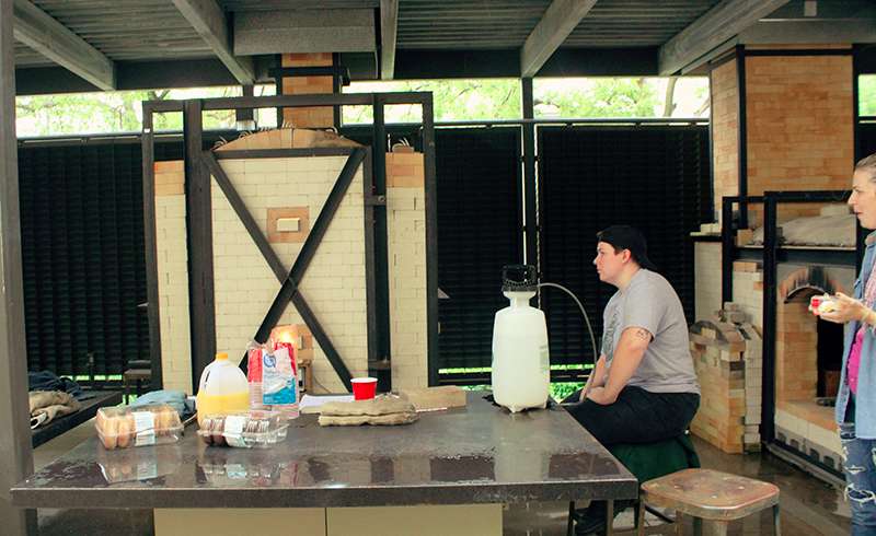 Students Tuesday fire ceramics in a wood-fire kiln at FHSU. Photo by Cristina Janney/Hays Post<br>