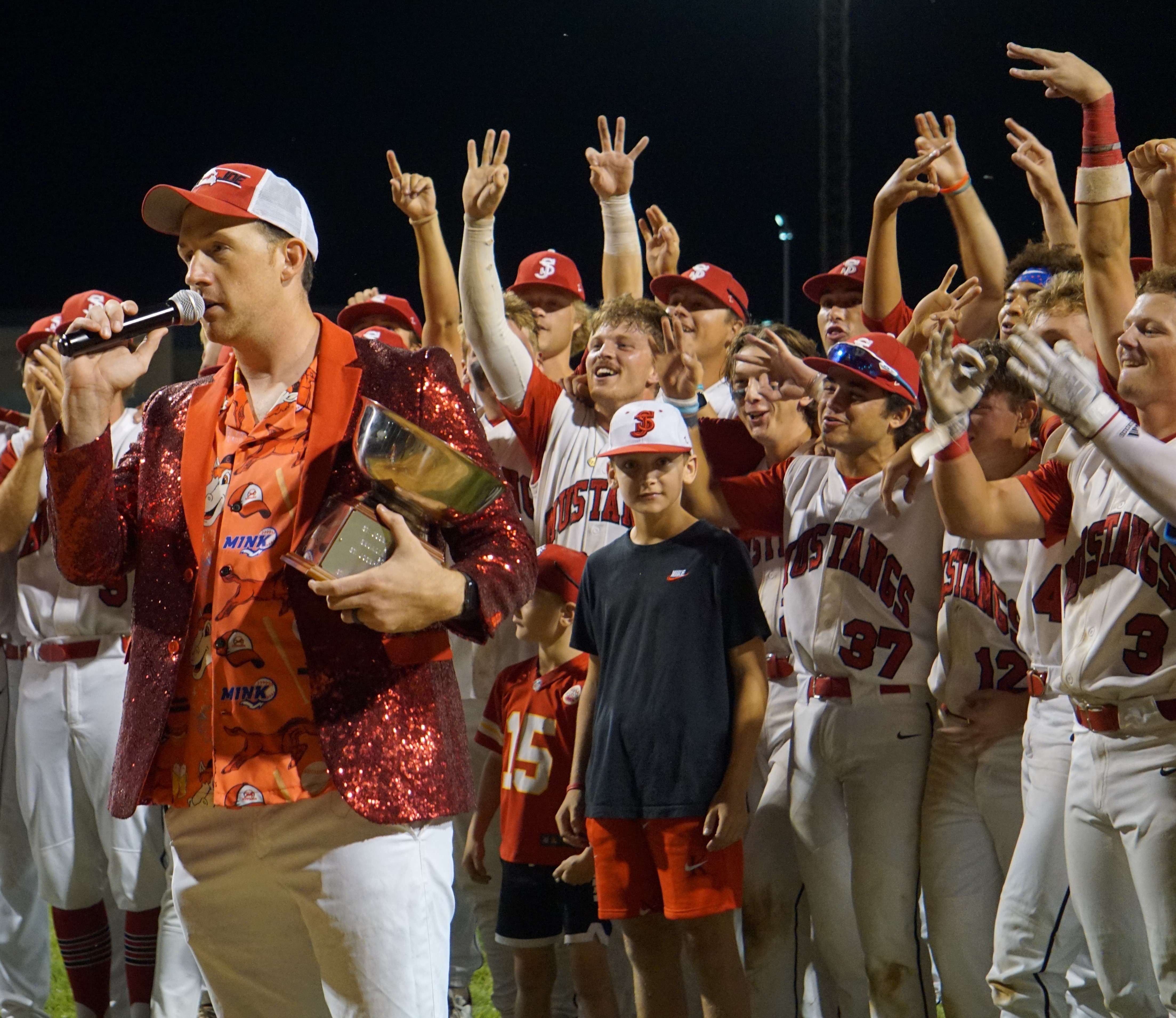 Mustangs general manager and owner Ky Turner (left) addresses the crowd as the players celebrate behind him, giving ode to their threepeat.