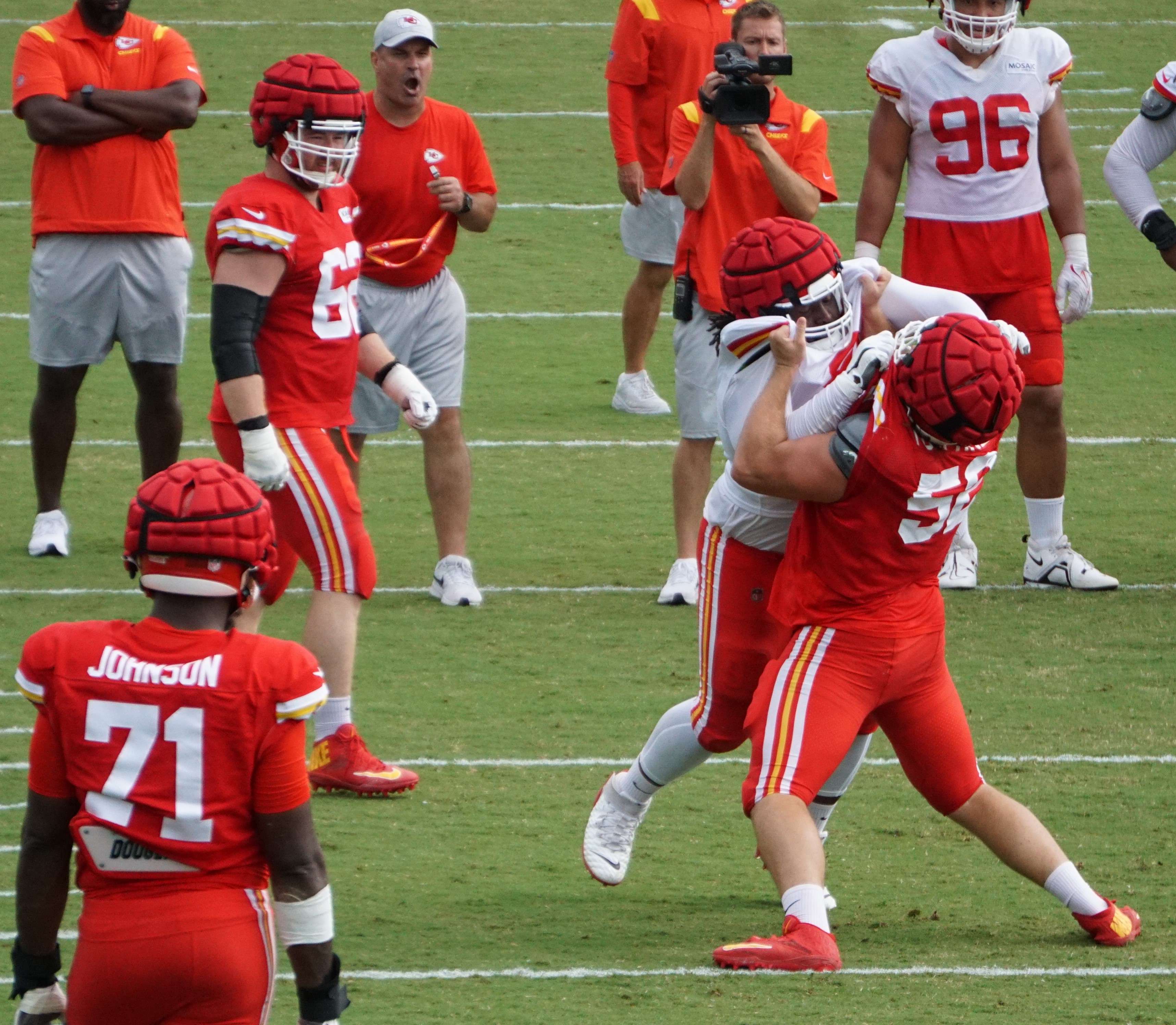 Creed Humphrey (red) and Derrick Nnadi (white) in a blocking drill.