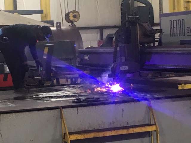 While the boilers are essentially built by hand, parts are needed for the project. Here a computer-operated plasma cutter produces parts for an order.