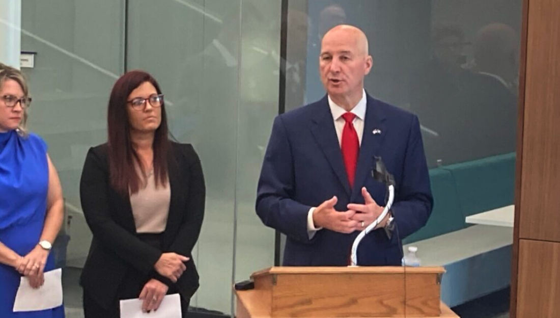 Gov. Pete Ricketts was joined at a Tuesday press conference by two Nebraskans who attended the Western Governors University, from left, Brenda Soto and Amanda Redler. (Paul Hammel/Nebraska Examiner)