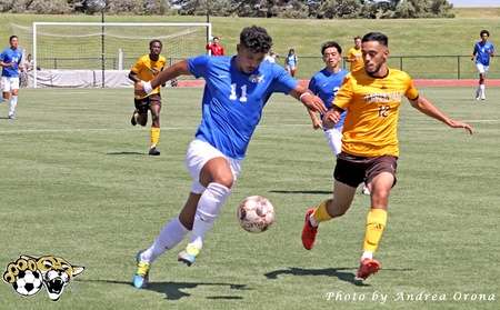 Barton men's soccer player Genildo Postimo drives past Garden City's Hedi Achab-Barton Athletics