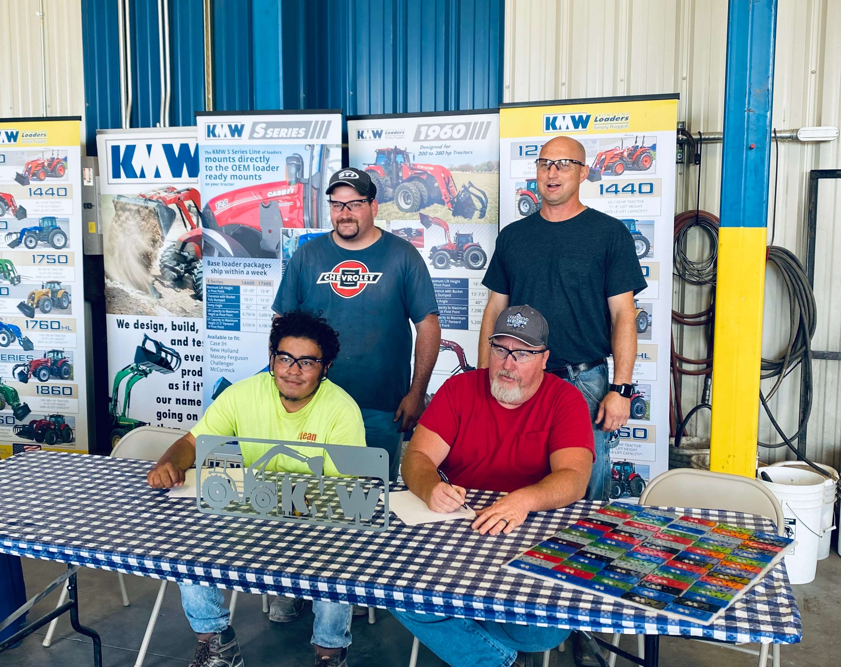 Two candidates sign letters to join KMW Loaders' apprenticeship program at a press conference on Thursday, Sept. 1, 2022.
