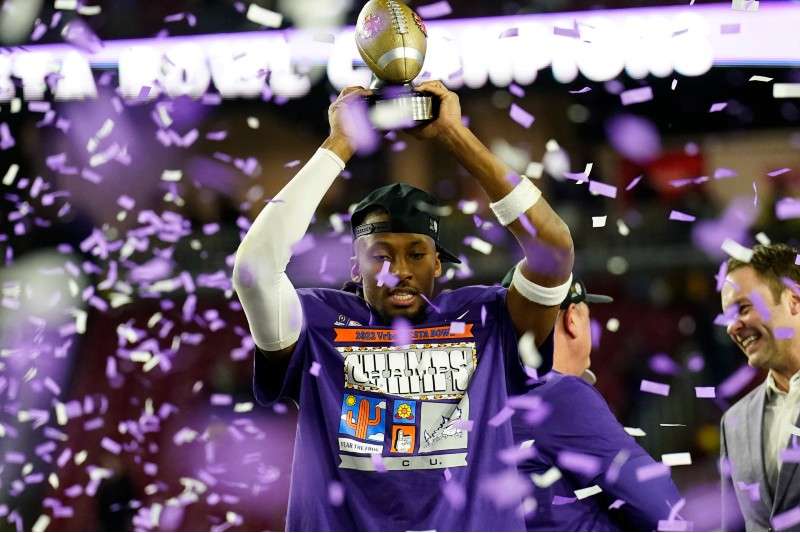 <b>TCU wide receiver Quentin Johnston holds the trophy after the Fiesta Bowl NCAA college football semifinal playoff game, Saturday, in Glendale, Ariz. TCU defeated Michigan 51-45.</b> (AP Photo/Ross D. Franklin)