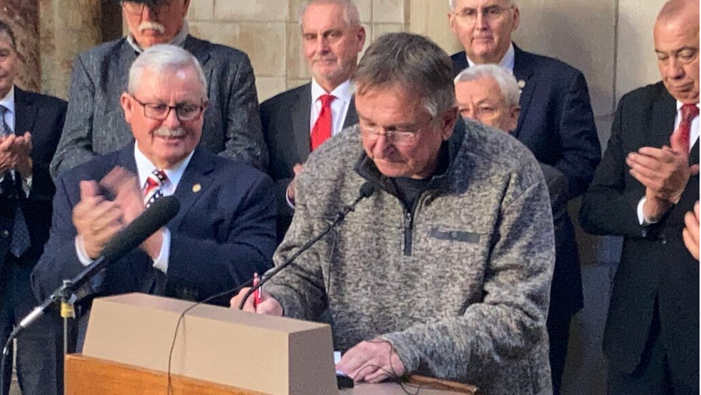 Craig Bohls, a Palmyra farmer, was the first signer Thursday on a petition drive to allow Nebraskans to vote on a consumption tax in 2024. State Sen. Steve Erdman, a leading proponent, at left, looks on. (Paul Hammel/Nebraska Examiner)