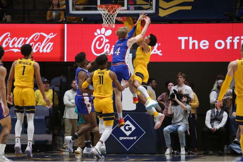 <b>West Virginia forward Tre Mitchell (3) shoots while defended by Kansas guard Gradey Dick (4) during the first half the game in Morgantown, W.Va., Saturday.</b> (AP Photo/Kathleen Batten)