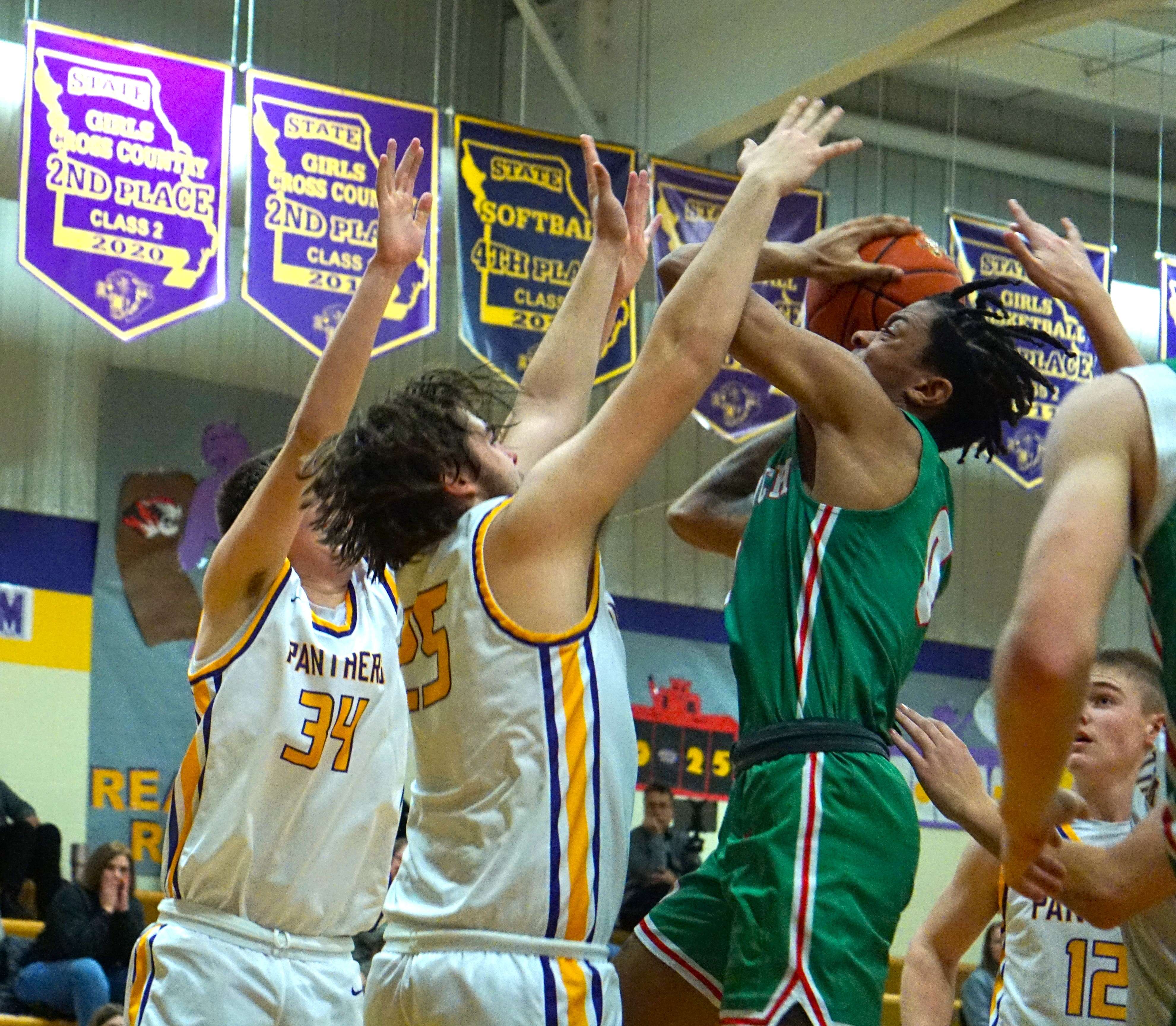 Joe Clark (right) tries to get past Westin Snook (34) and Creek Johnson (25).