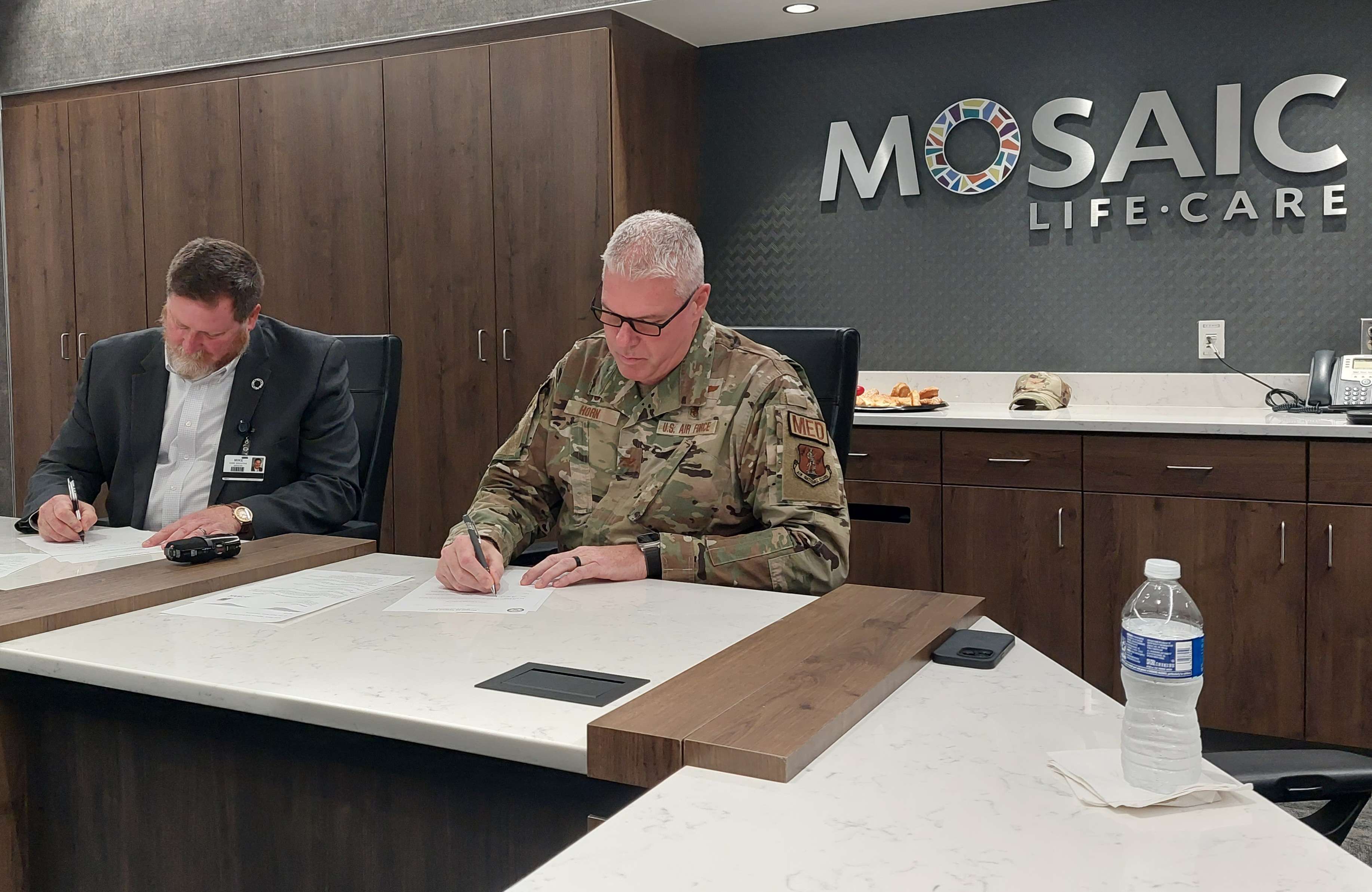Mosaic Life Care CEO Mike Poore (left) and Colonel Jason Horn Commander of the 139th Medical Group (right) sign the partnership agreement/ Photo by Matt Pike