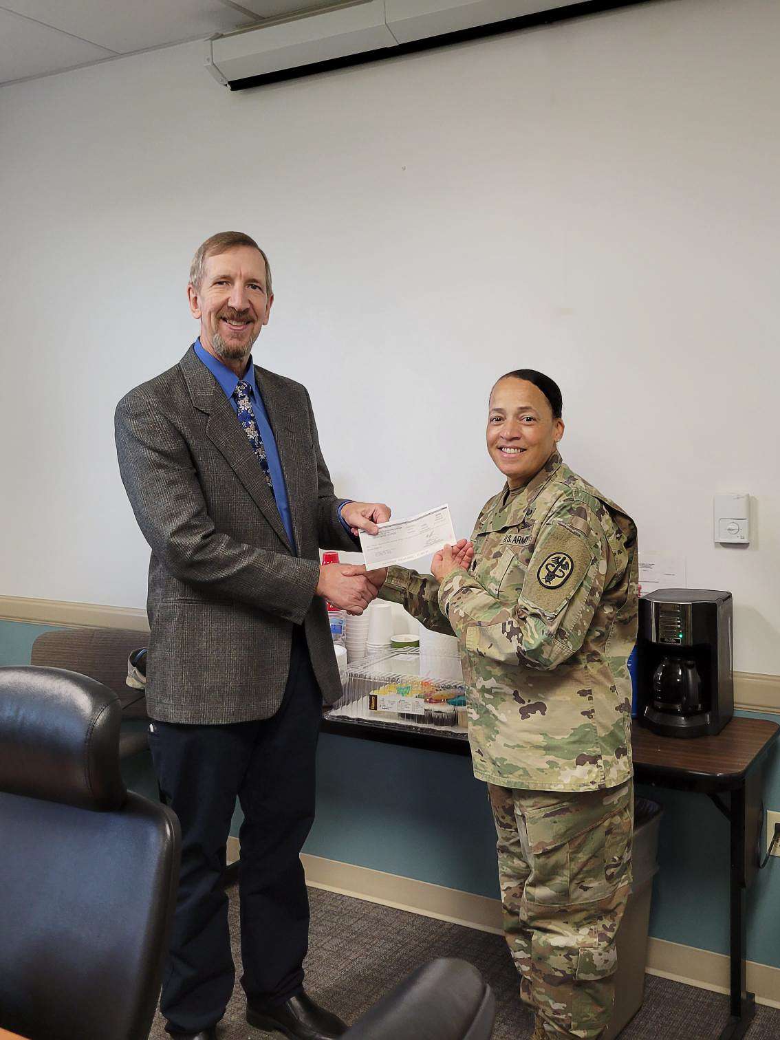 (Left) Barton Dean of Military Academics, Technical Education and Outreach Programs Kurt Teal presents a check from proceeds of the annual Wounded Warrior Golf Scramble for $3,250 to Lieutenant Colonel and Soldier Recovery Unit Commander Yolanda Ahmad.