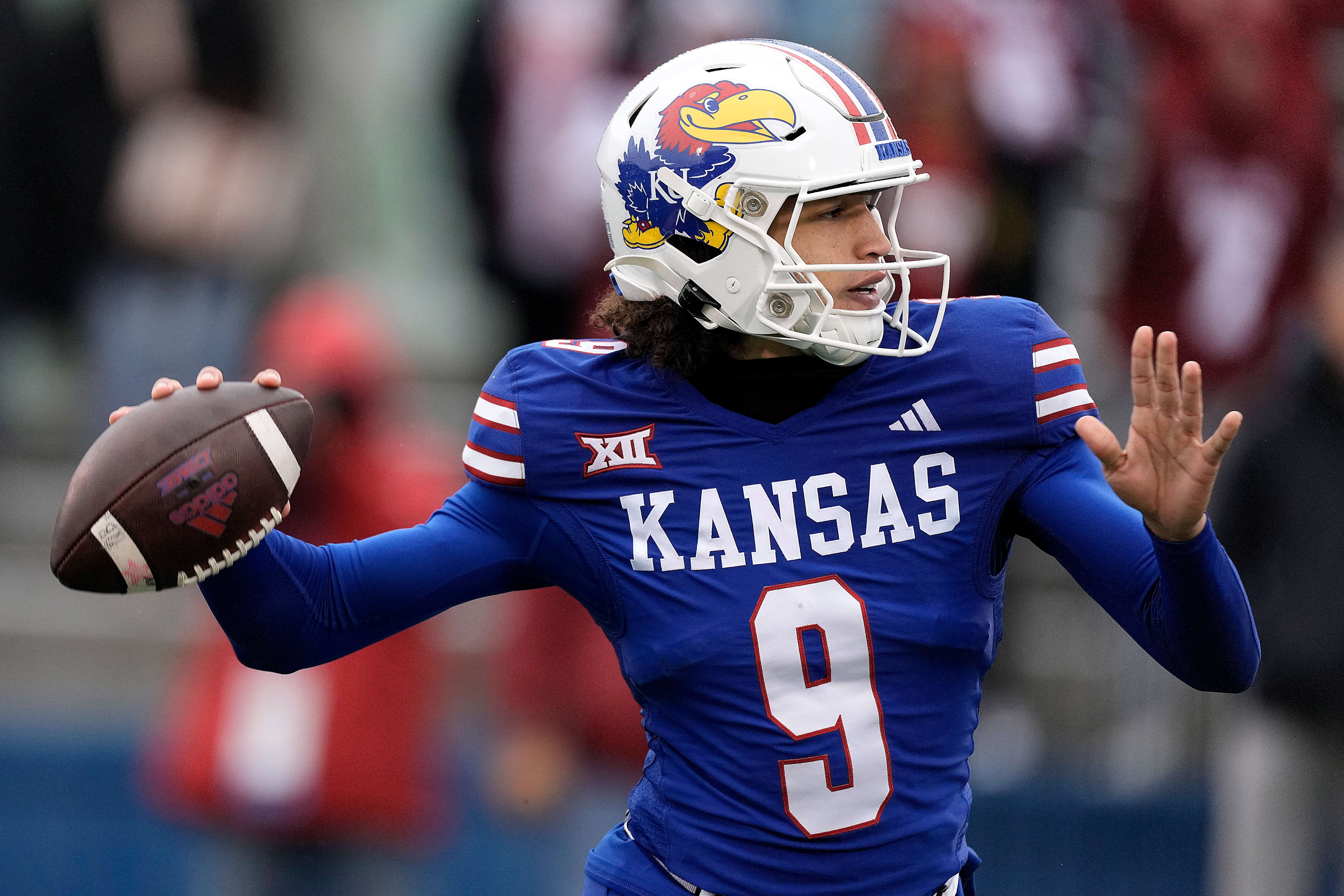 Kansas quarterback Jason Bean looks to pass during the second half of an NCAA college football game against Oklahoma Saturday, Oct. 28, 2023, in Lawrence, Kan. Kansas won 38-33. (AP Photo/Charlie Riedel)