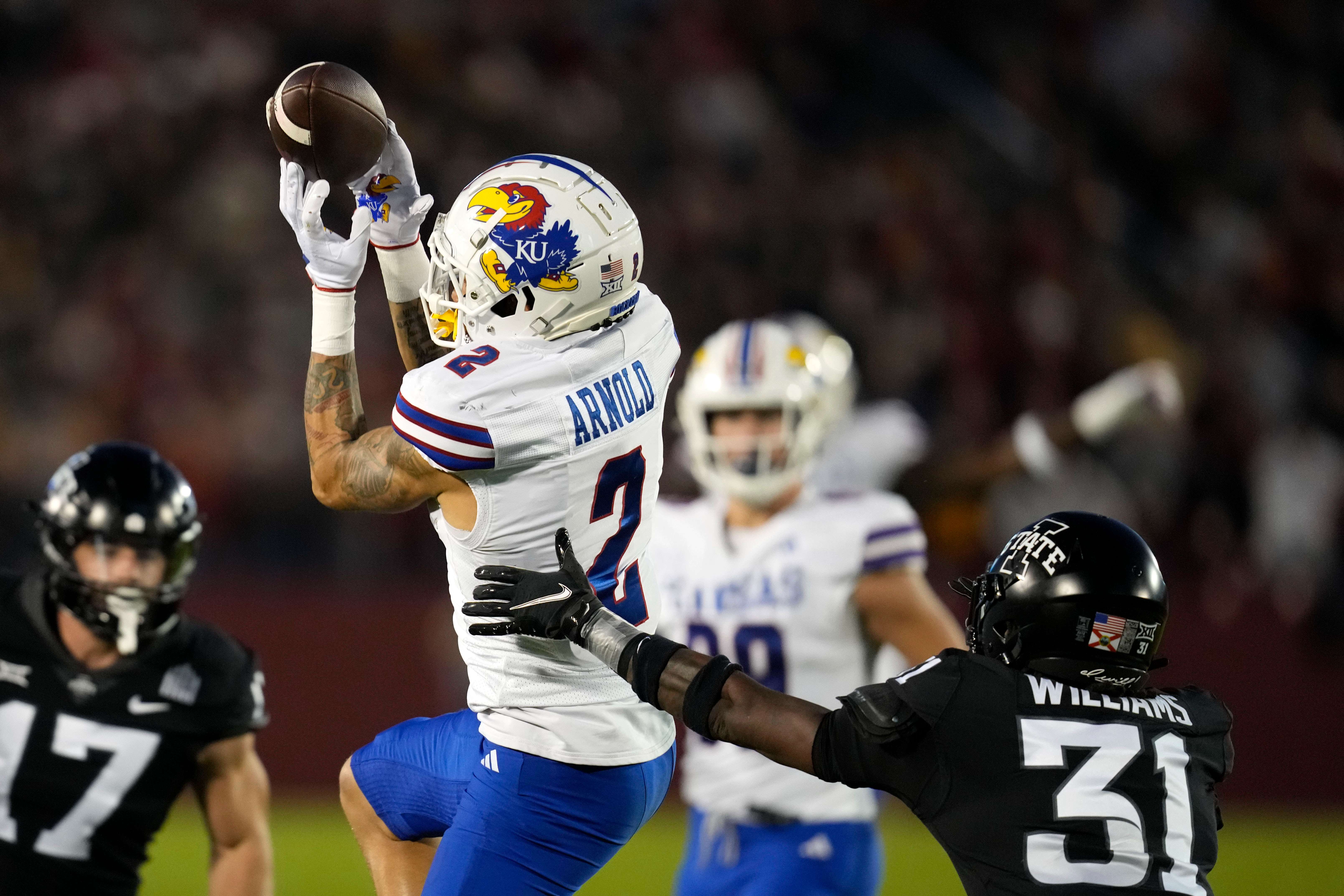 Kansas wide receiver Lawrence Arnold (2) catchers a pass over Iowa State defensive back Jontez Williams (31) during the first half of an NCAA college football game, Saturday, Nov. 4, 2023, in Ames, Iowa. (AP Photo/Charlie Neibergall)