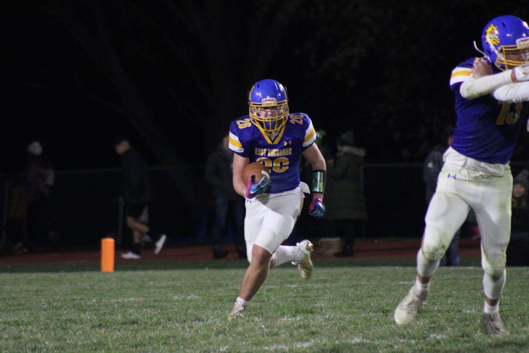 Junior running back Aidan Smith (26) rushes around his offensive lineman. Photo by Clifton Grooms.