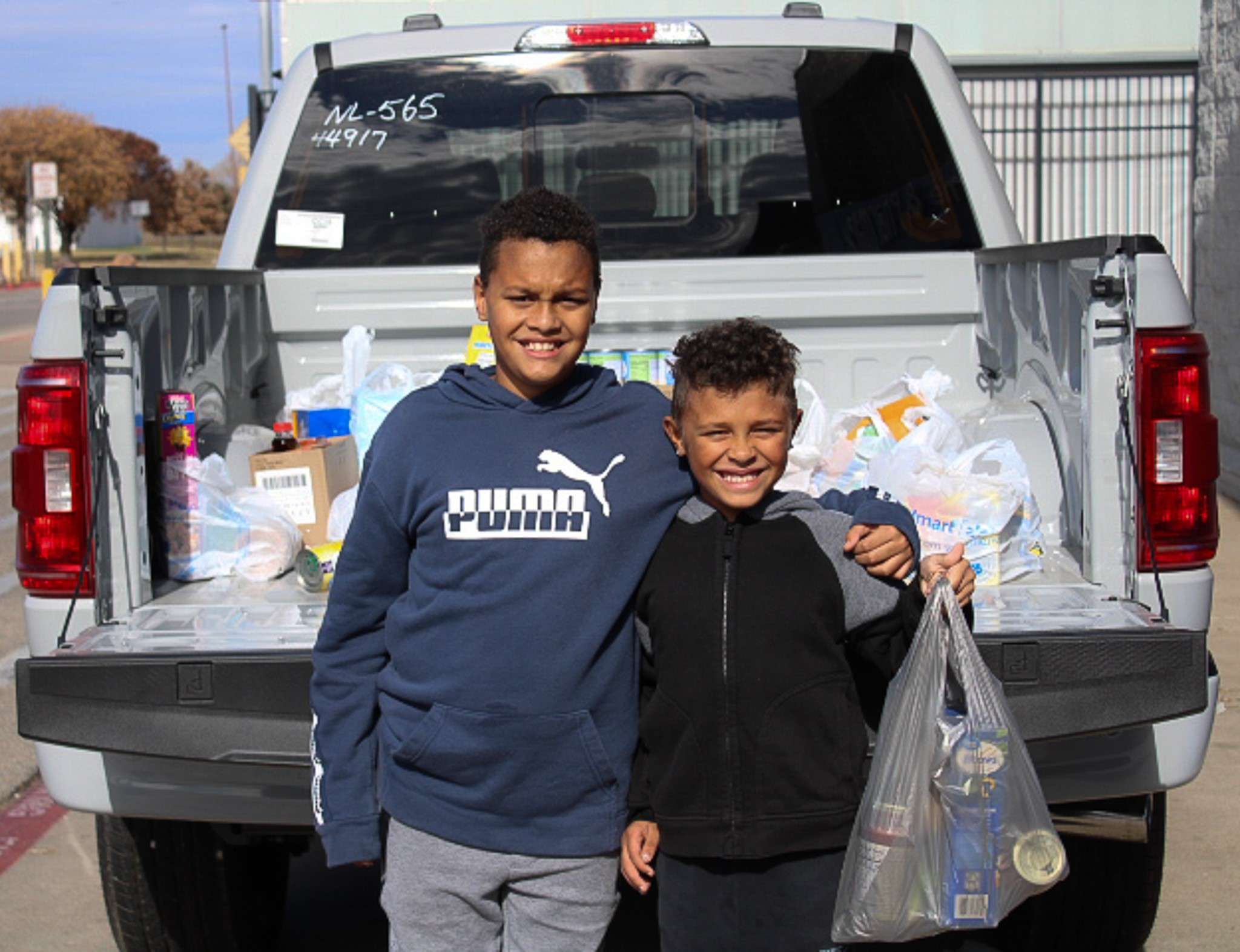 Orion and Lincoln Field contribute to Stuff the Trucks on Saturday, Nov. 11, 2023. Photo by Emmie Boese.