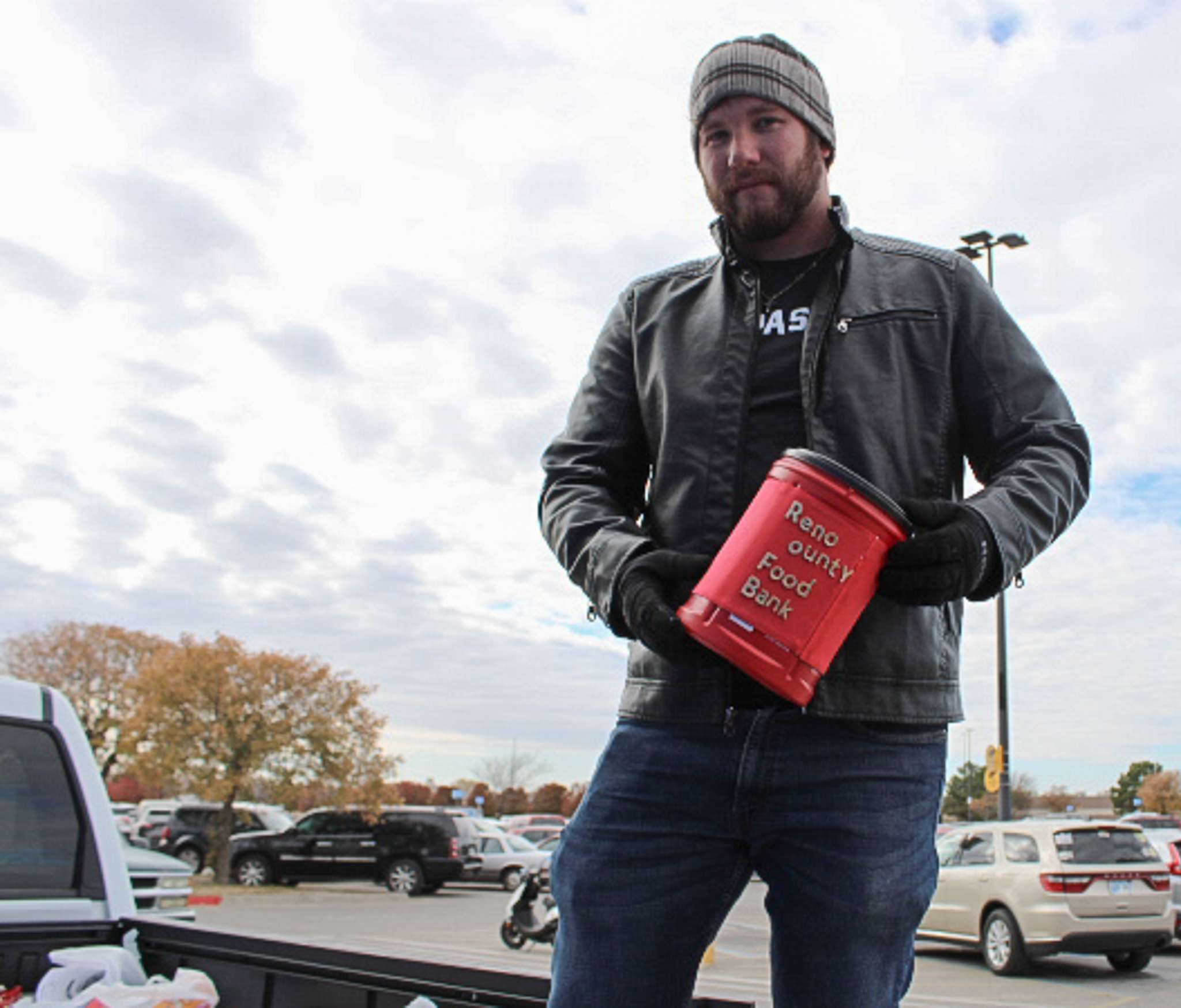 Kyle Reece of Midwest Superstore holds up a cash donation jar to purchase food items for the Reno County Food Bank on Saturday, Nov. 11, 2023. Photo by Emmie Boese.&nbsp;