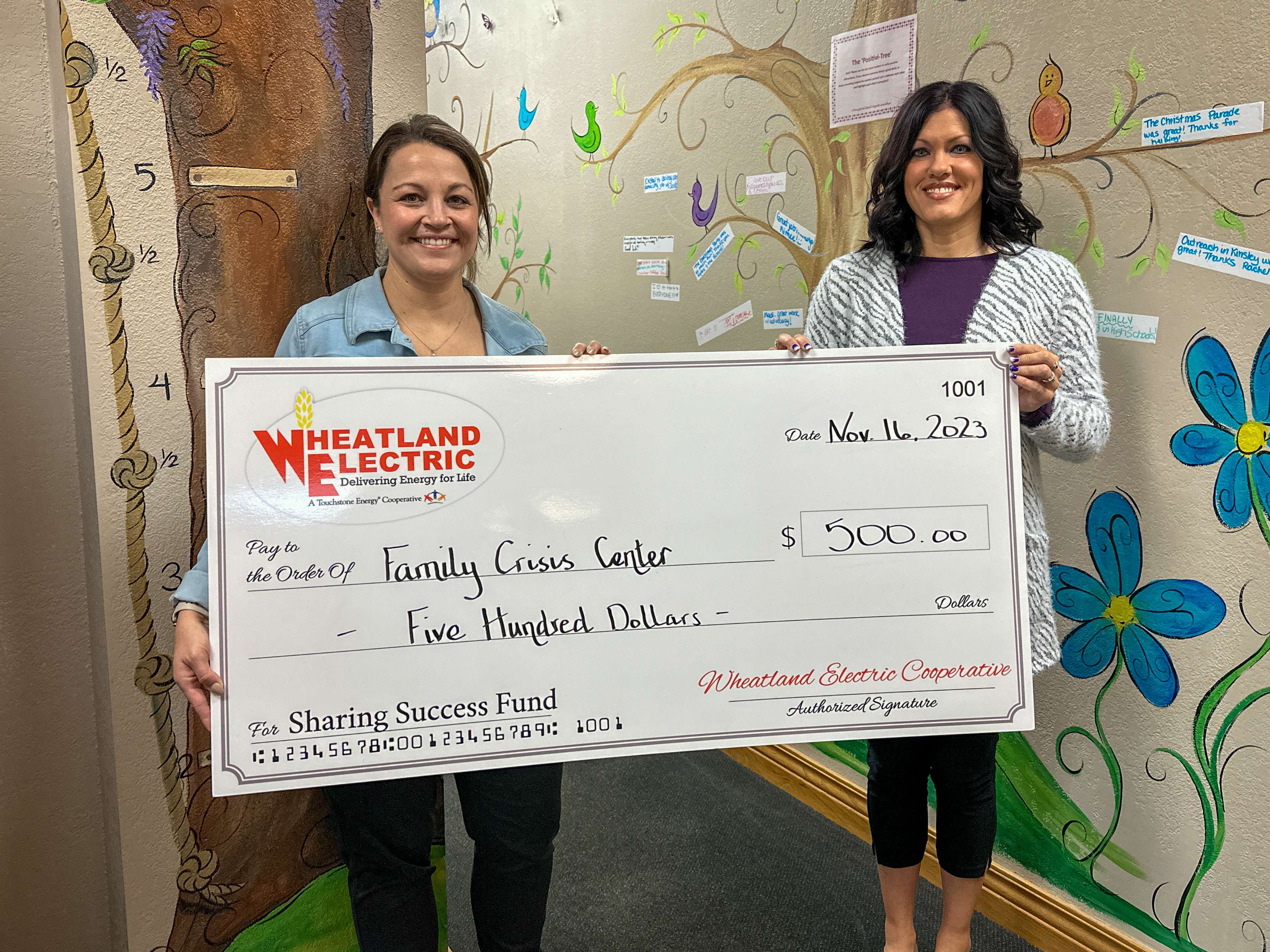 Saylem Ryff (left), program director, and Kylee Graves, executive director, accept a $500 Sharing Success grant for their fourth-place finish in the Sharing Success Charity Challenge through Wheatland Electric.