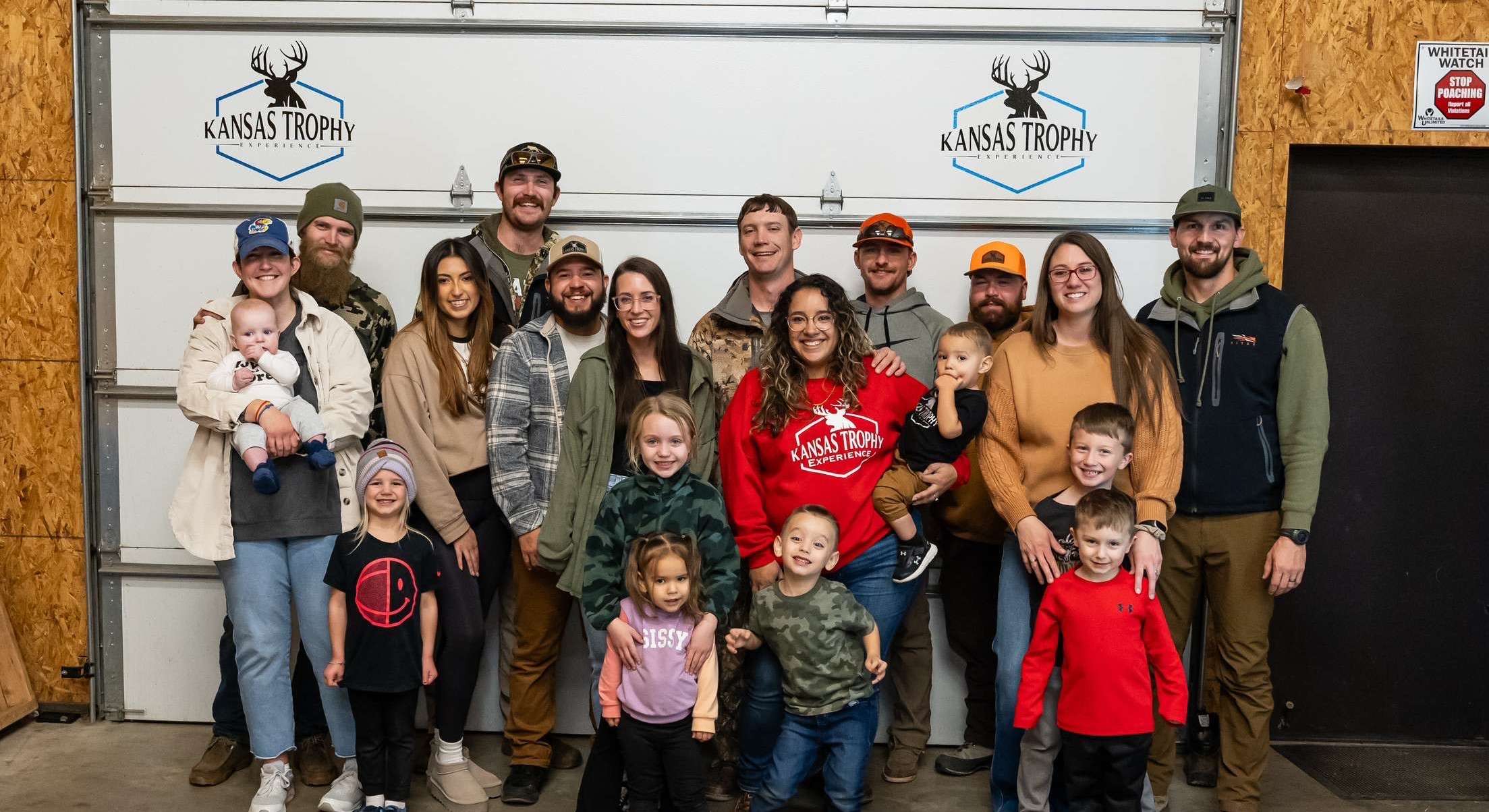 Kansas Trophy Experience, MPIRE Realty, and USD 428 have teamed up to hand out 500 pounds of deer meat to families in need. Pictured with their families are Kansas Trophy Experience Guides&nbsp;Guides Cody Huddleston, Brayden Smith, Trevor Olsen, Billy Eldridge, Dylan Frazee, Gavin O'Donnell, and Devon Degenhardt. Not pictured: Wally Eldridge.