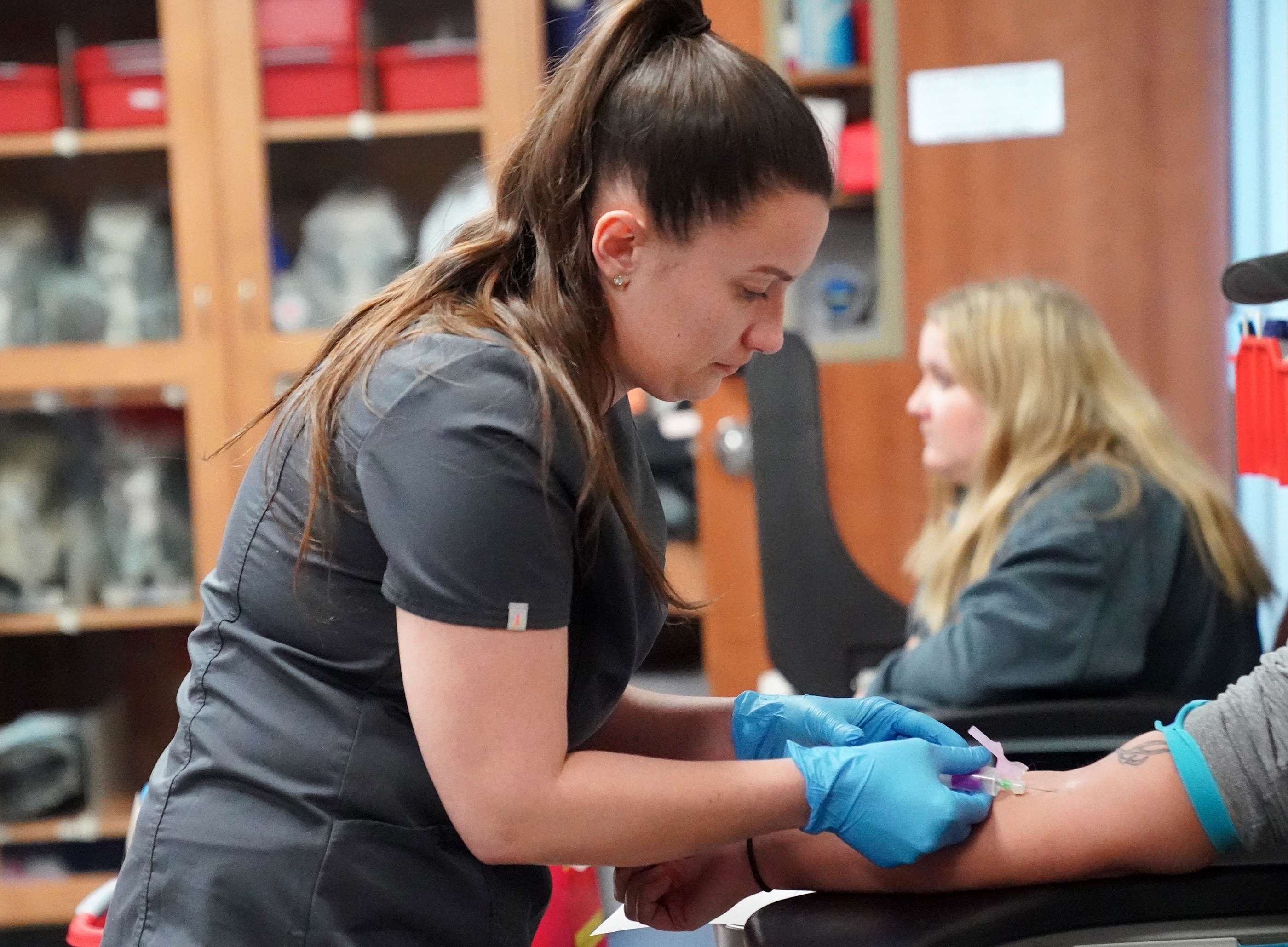 <i>Mid-Plains Community College student Courtney Montannia, of North Platte, draws blood on a patient Tuesday as part of the Medical Laboratory Technician program. MPCC will offer a Fundamentals of Phlebotomy class at its McCook and North Platte campuses starting next month.</i>