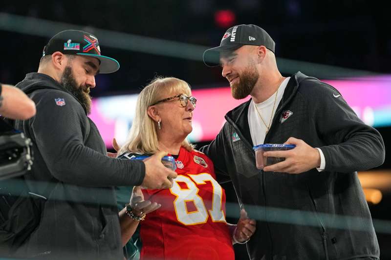 <b>Donna Kelce greets her sons, Philadelphia Eagles center Jason Kelce, left, and Kansas City Chiefs tight end Travis Kelce during the NFL football Super Bowl 57 opening night Monday in Phoenix. The Kansas City Chiefs will play the Philadelphia Eagles on Sunday. </b>(AP Photo/Matt York)