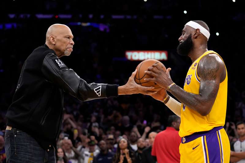 Kareem Abdul-Jabbar, left, hands the ball to Los Angeles Lakers forward LeBron James after passing Abdul-Jabbar to become the NBA's all-time leading scorer during the second half of an NBA basketball game against the Oklahoma City Thunder Tuesday, Feb. 7, 2023, in Los Angeles. (AP Photo/Ashley Landis).jpg
