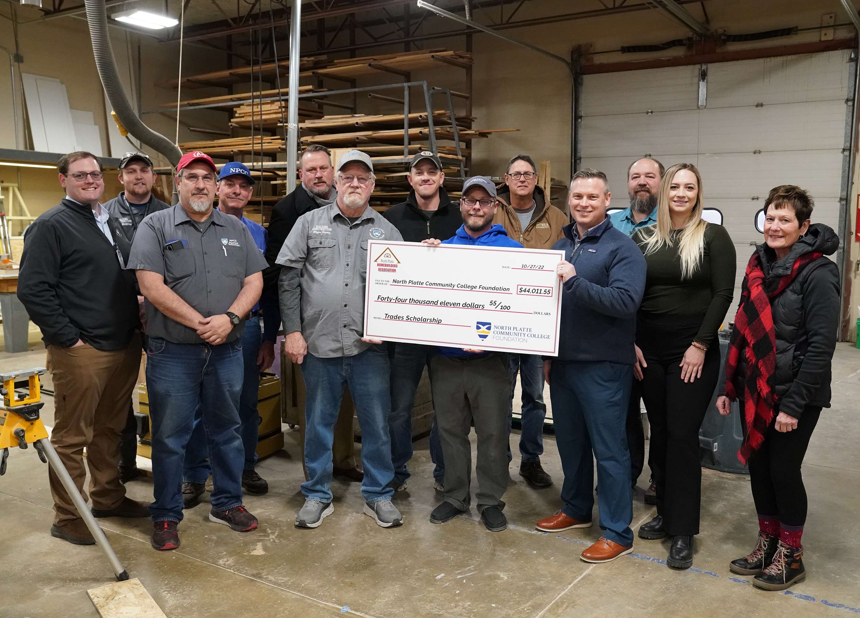 Representatives from the North Platte Home Builders Association, members of the North Platte Community College Foundation and instructors from the college’s applied technology programs stand next to a check for $44,011.55 Wednesday morning on the NPCC North Campus.