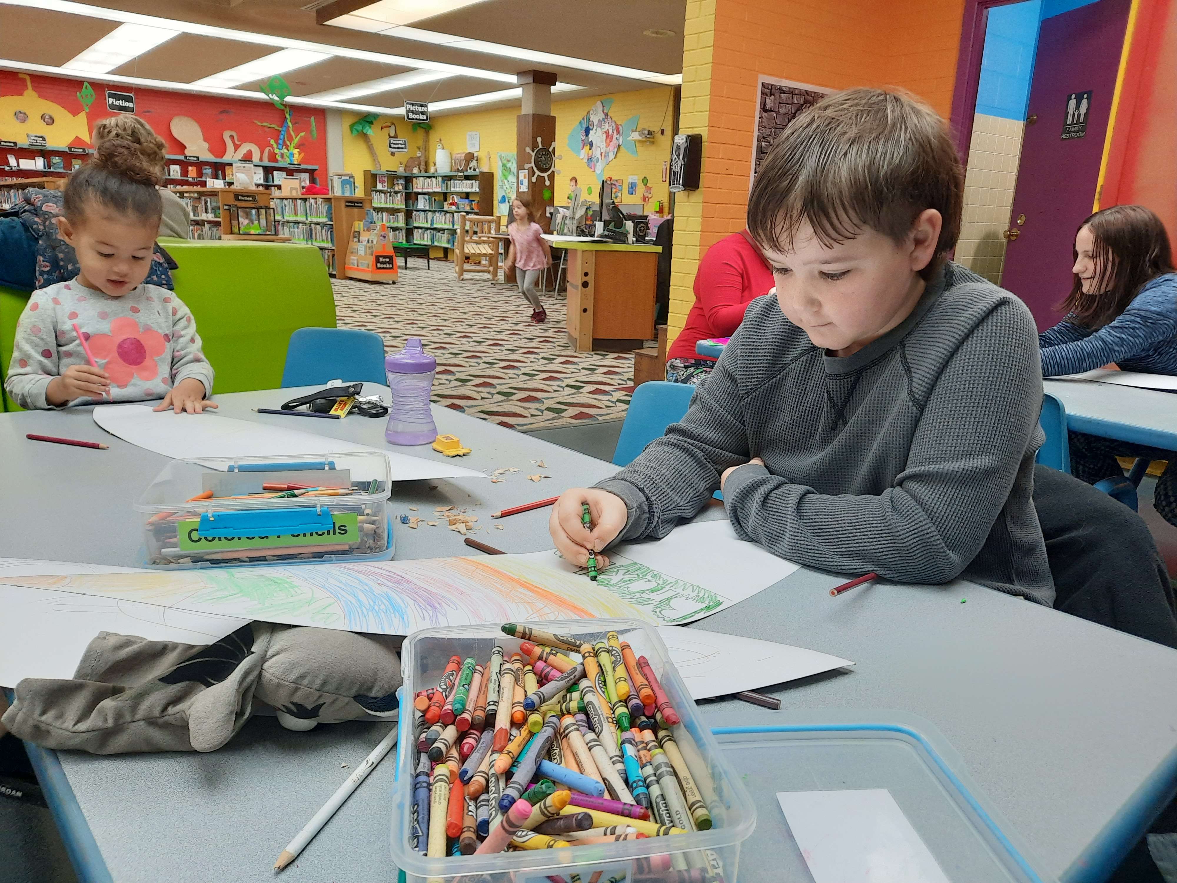 Braxton Tucker and Lizzy Gray decorate their surfboards Monday morning at the Great Bend Public Library.
