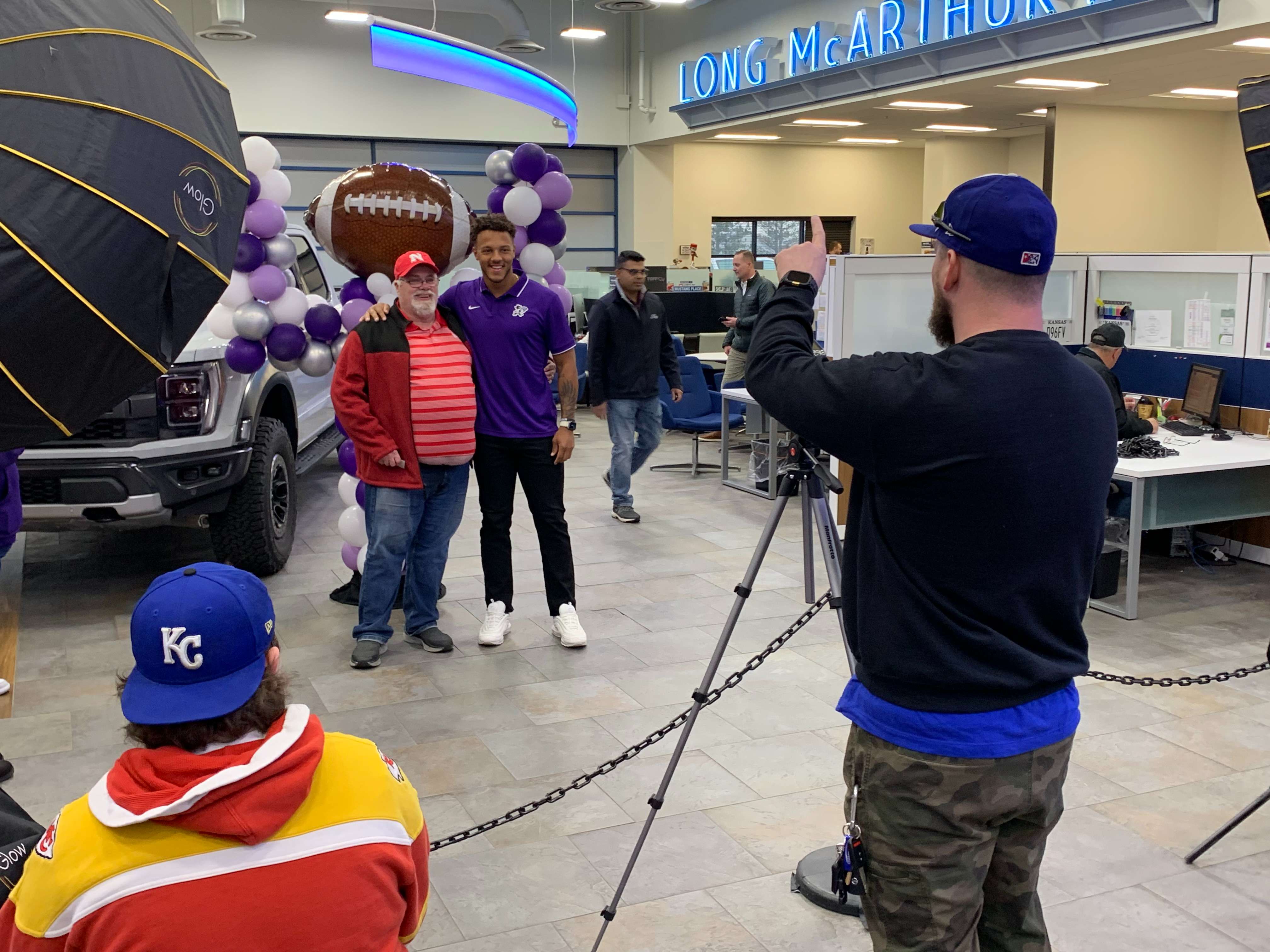 <b>K-State's quarterback Adrian Martinez poses with a fan.</b>