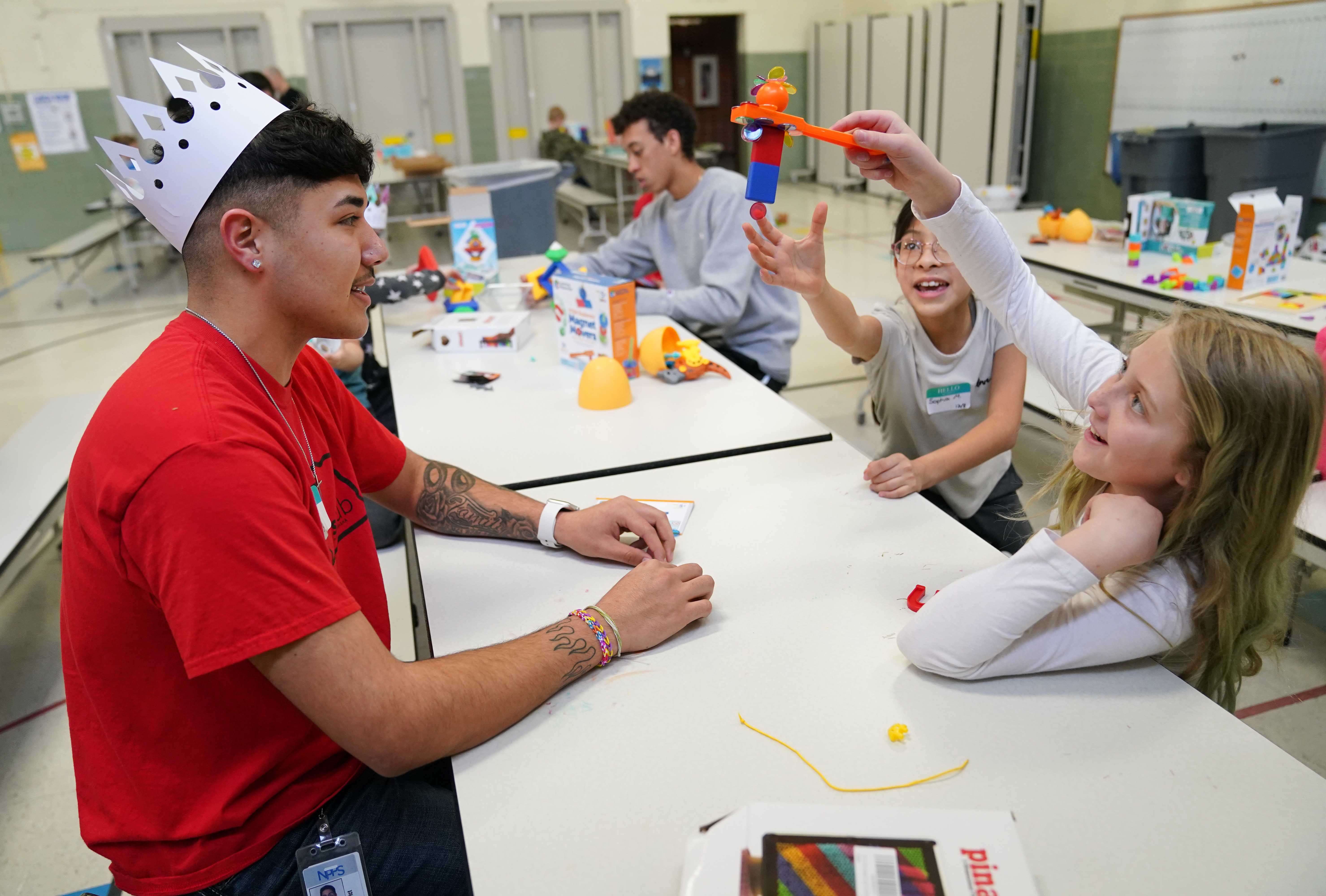 North Platte Community College student Matthew Wright helps Kids Klub members Sophia Moreno and Serenity Schade build a project with magnets Wednesday during Mega Day at Jefferson Elementary. Wright works for both Kids Klub and Helping Hands.