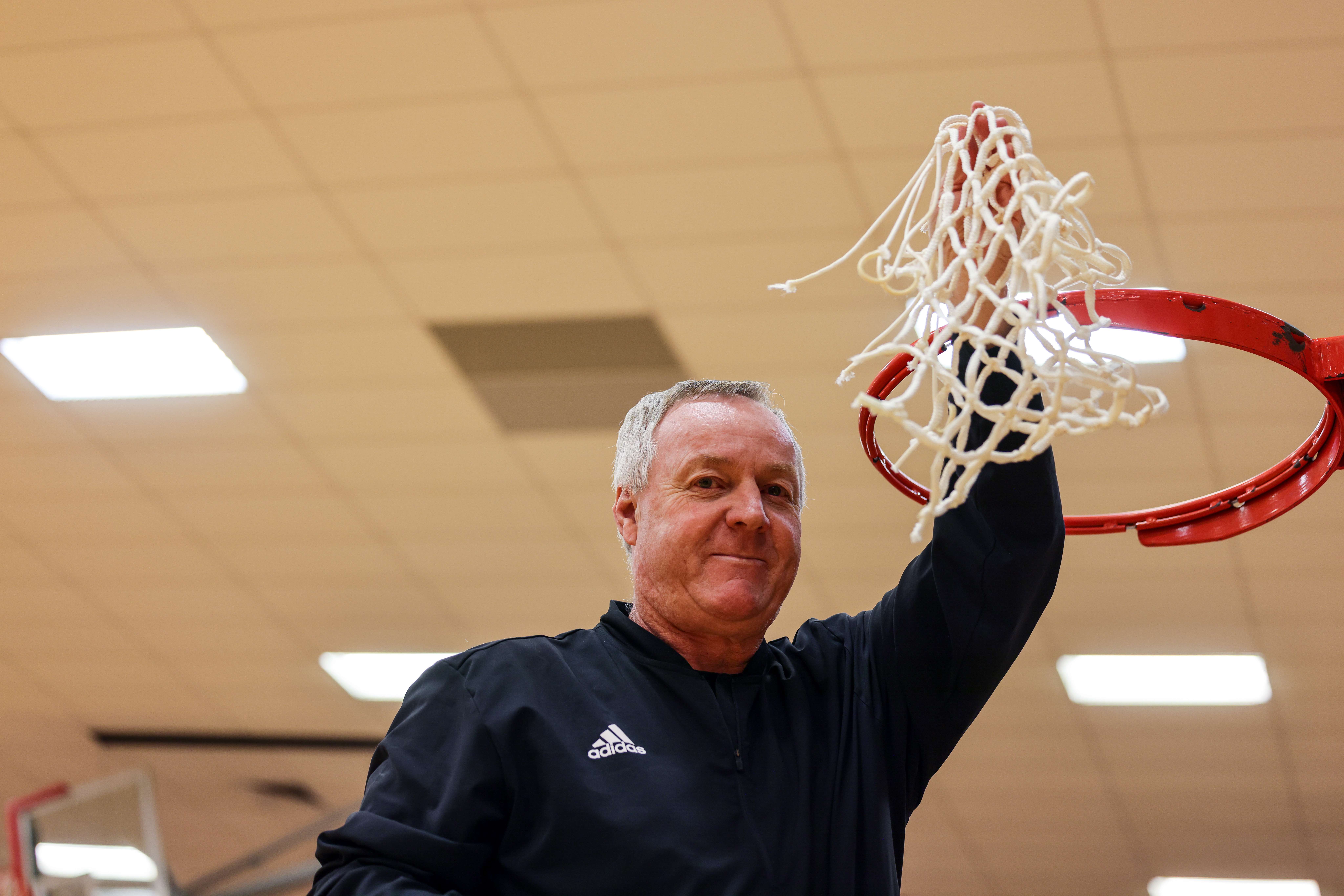 Alan Clark, Barton Community College women's basketball coach, was able to cut down the nets this year after winning the Region VI Championship on March 11. The Cougars will play in the NJCAA National Tournament on Wednesday, March 22. (photo by Ed Bailey)