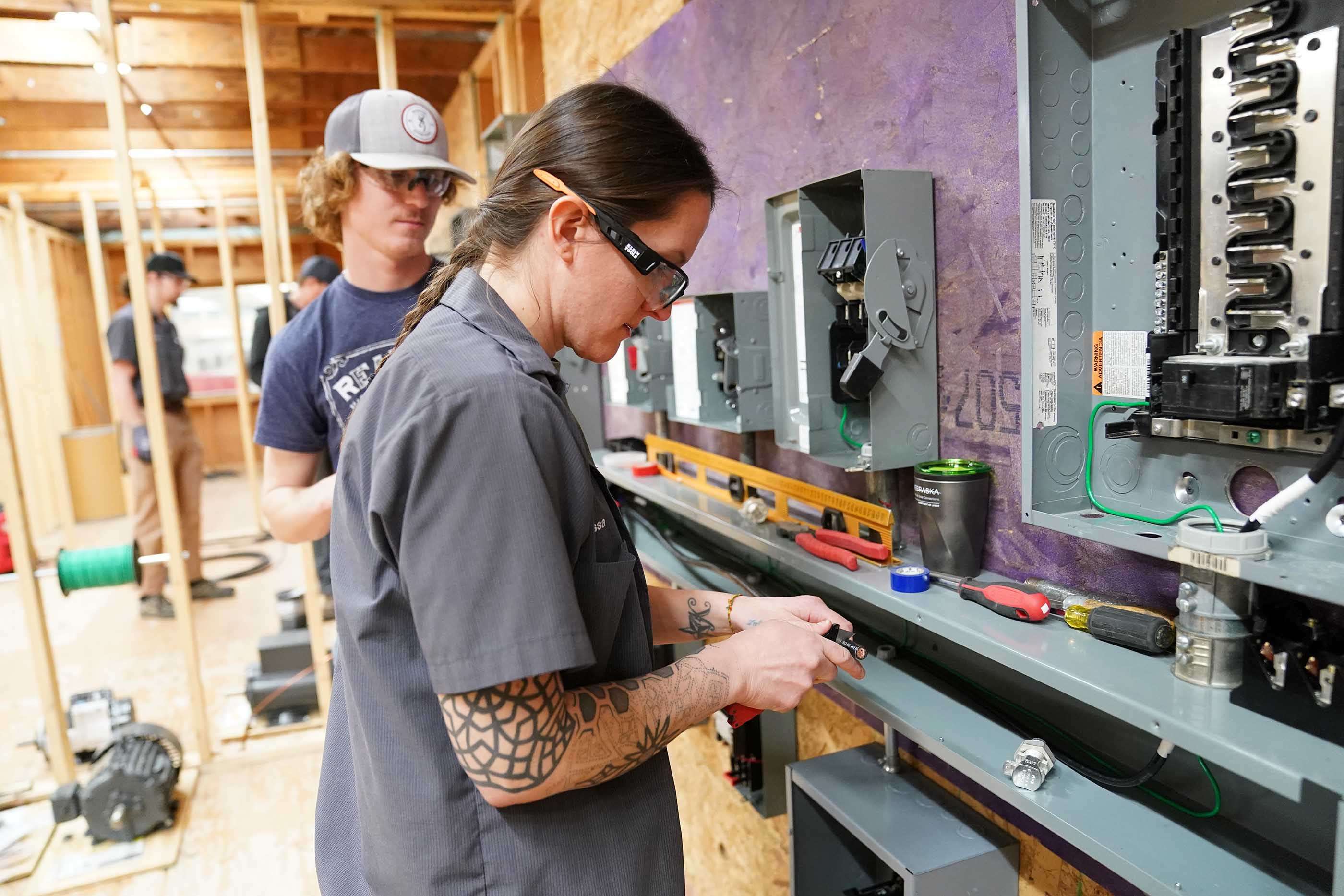 North Platte Community College electrical student Andrew Dowse, of Sutherland, watches as his classmate Alyssa Stark, of North Platte, splices a wire while working on a custom grain bin mock-up trainer the college recently purchased.