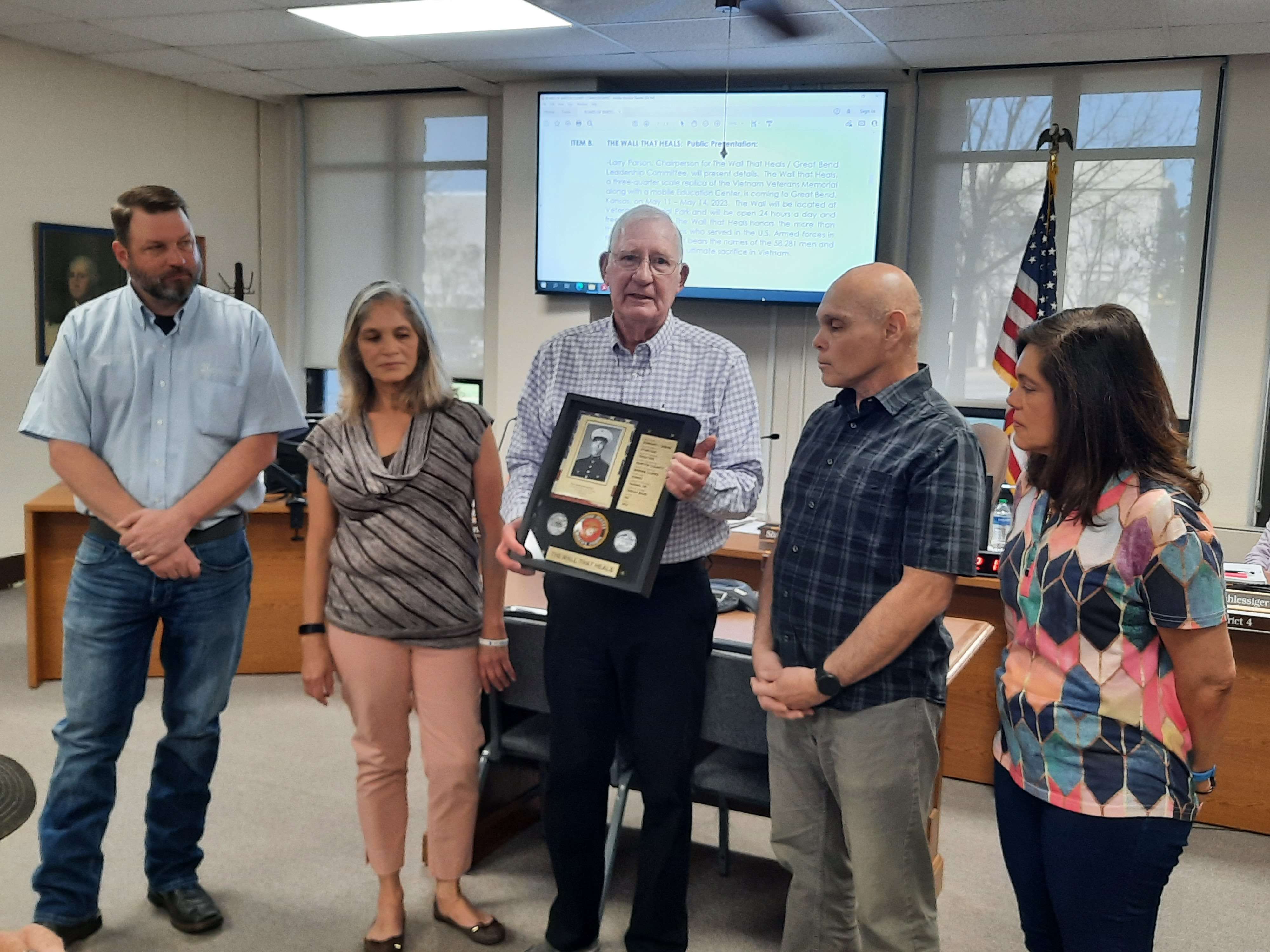 Larry Parsons, chairperson for The Wall That Heals, presented a shadowbox to the family of Vietnam Veteran Edward Saenz during Wednesday's Barton County Commission meeting.