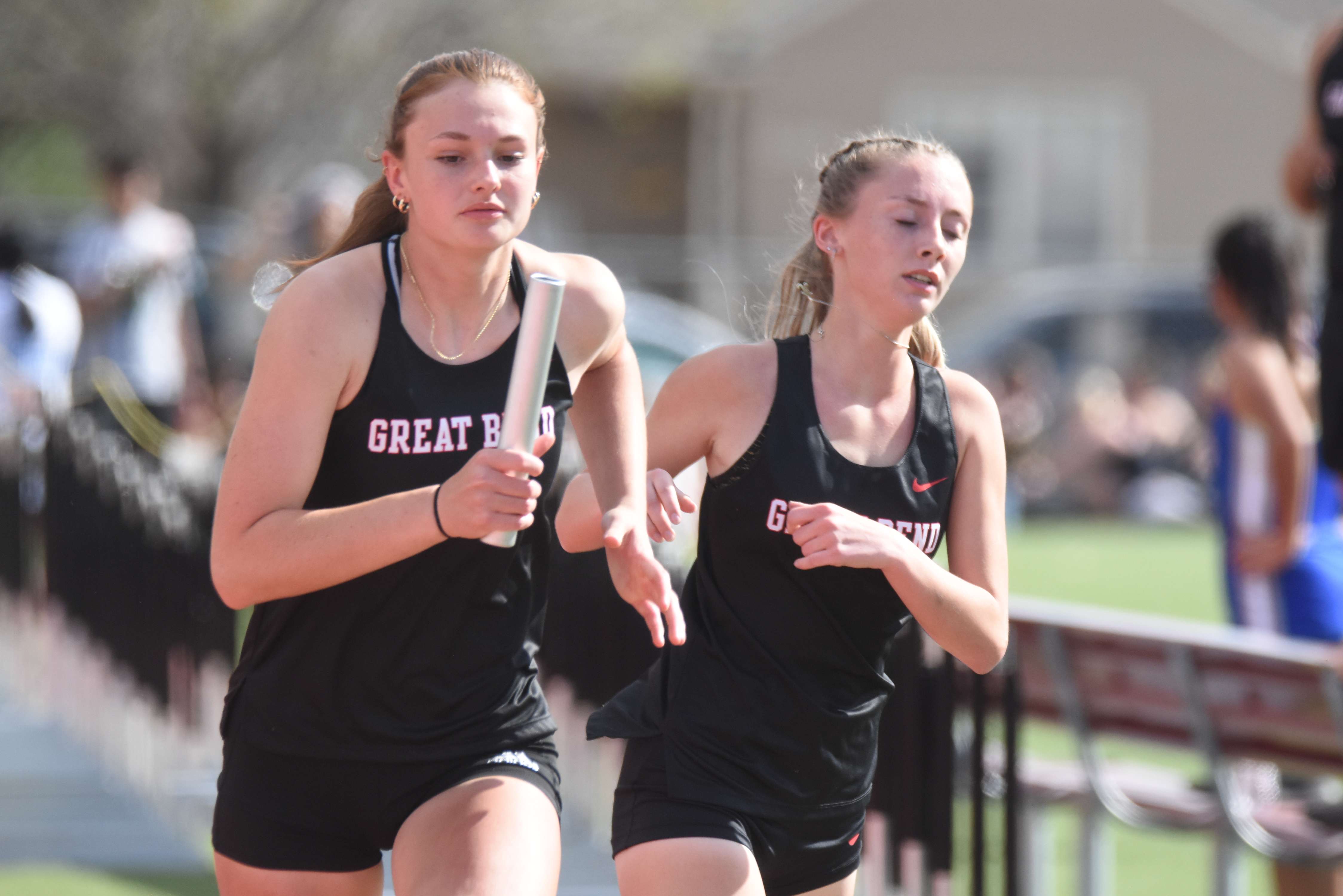 Cassie Ellegood takes the baton from Kate Welcher during the 4x800m relay in Friday's Jack Bowman Invitational.