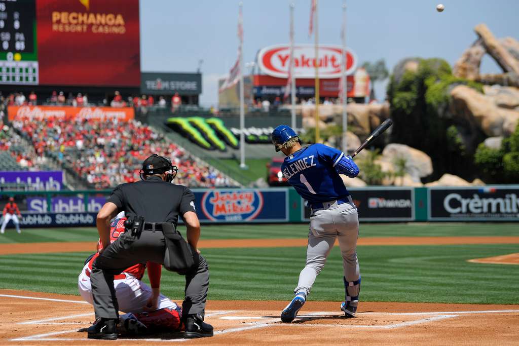 Kansas City Royals' MJ Melendez, right, hits a solo home run as Los Angeles Angels catcher Chad Wallach, left, and home plate umpire Shane Livensparger watch during the first inning of a baseball game Sunday, April 23, 2023, in Anaheim, Calif. (AP Photo/Mark J. Terrill)