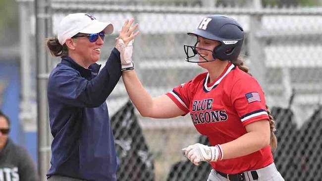 Blue Dragon first baseman Aspen Goetz receives a high-five from head coach Jaime Rose after a grand slam in Game 2 on Thursday against Seward County at Fun Valley. (Andrew Carpenter/Blue Dragon Sports Information)<br>