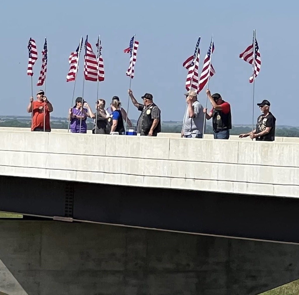 <b>Members of the community wave flags in support of the Run for the Wall.</b>