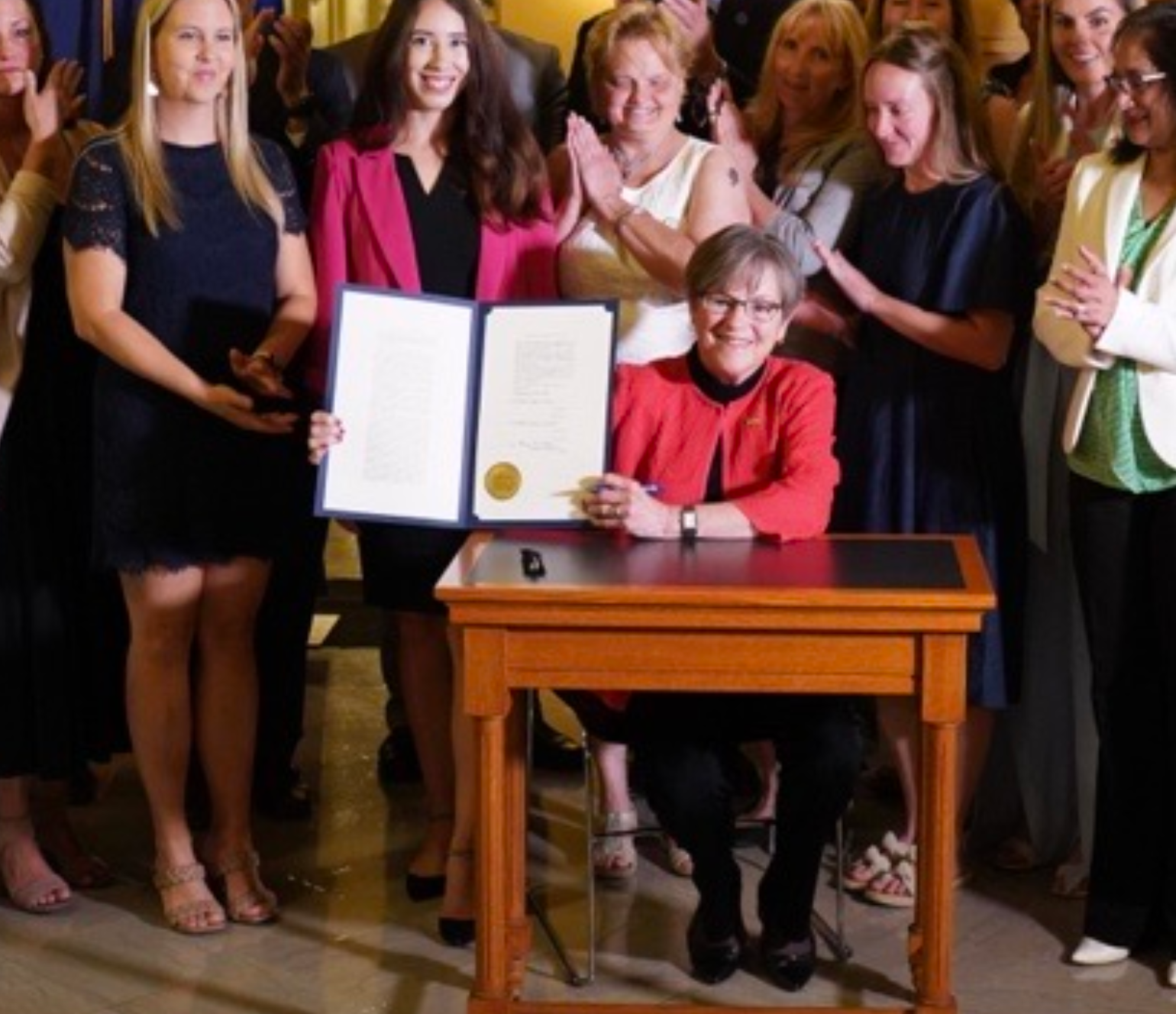 Gov. Laura Kelly celebrated with legislators and activists a new Kansas law eliminating the statute of limitations on criminal prosecution of child sexual abuse and expansion of the statute of limitations on filing lawsuits to seek damages in abuse cases. -courtesy photo