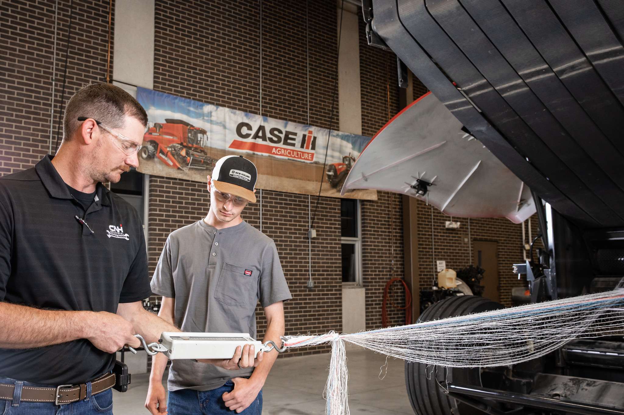Barton Instructor Mark Bogner (left) teaches a Case New Holland (CNH) employee about a piece of equipment on the Barton campus early this summer. Bogner is the instructor for the training program Barton facilitates for current CNH employees. The Top Tech program will be available to all people interested in starting a career as a CNH technician from the ground level.