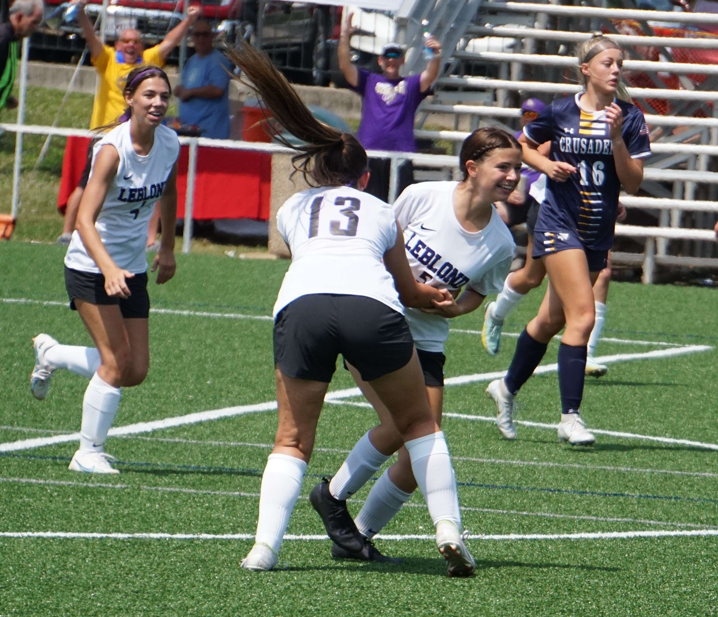 Emersyn McChristy (middle) celebrates after scoring a goal early in the second half of Saturday's third place match against Saxony Lutheran. Photo by Tommy Rezac.