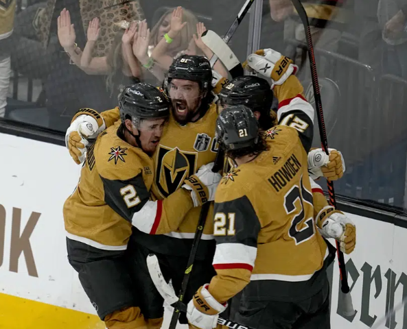 Vegas Golden Knights right wing Mark Stone, left, celebrates his goal against the Florida Panthers with Brett Howden (21), defenseman Zach Whitecloud (2) and center Chandler Stephenson during the third period of Game 1 of the NHL hockey Stanley Cup Finals, Saturday, June 3, 2023, in Las Vegas. (AP Photo/Abbie Parr)