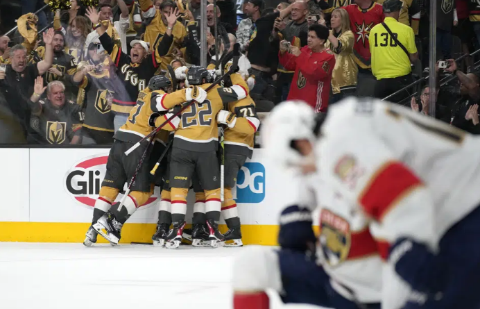 Members or the Vegas Golden Knights, left, celebrate a goal by right wing Reilly Smith as members of the Florida Panthers stand by during the second period in Game 5 of the NHL hockey Stanley Cup Finals Tuesday, June 13, 2023, in Las Vegas. (AP Photo/John Locher)