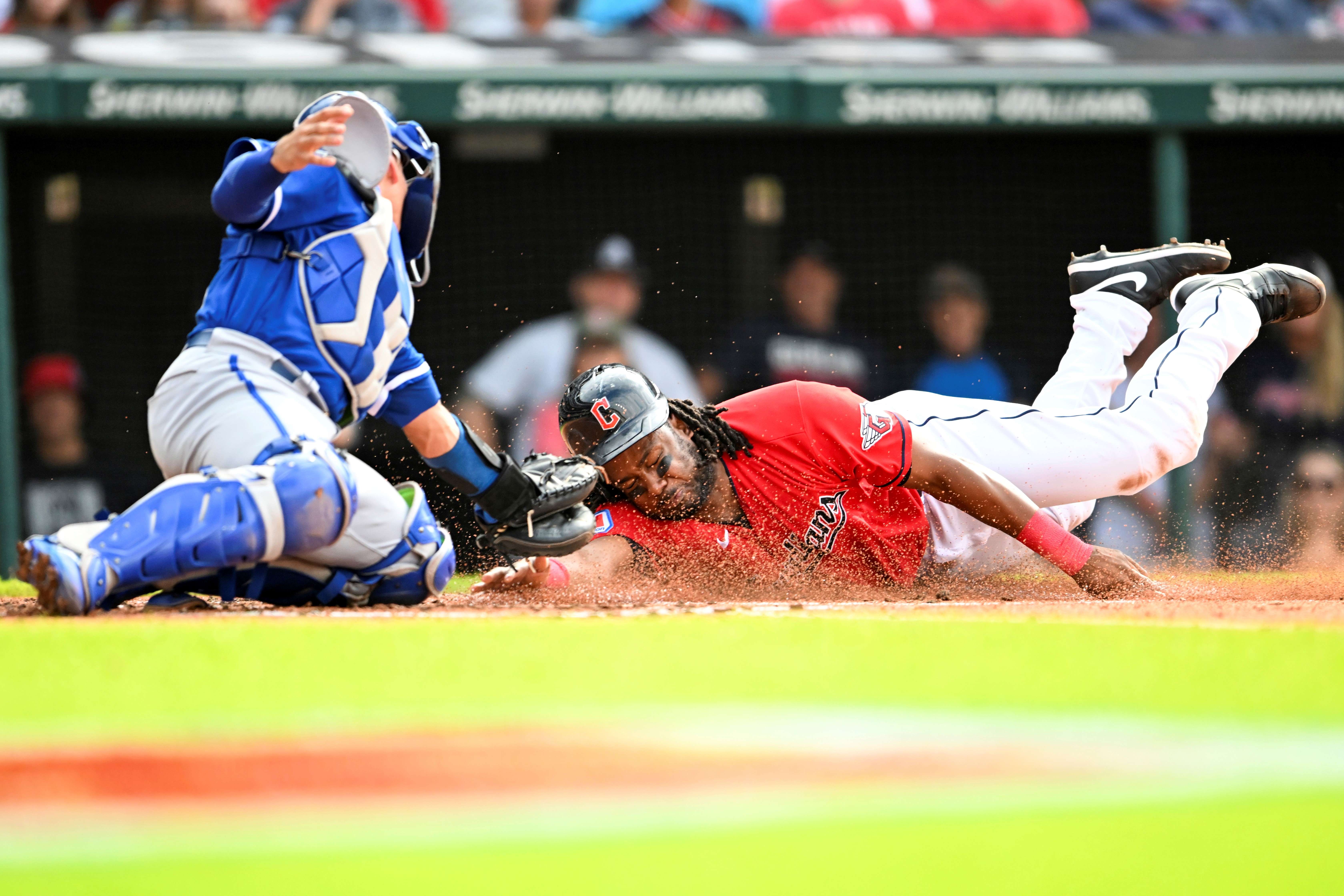 Cleveland Guardians' Josh Bell, right, scores against Kansas City Royals' Freddy Fermin, left, on a sacrifice fly hit by Myles Straw during the second inning of a baseball game, Saturday, July 8, 2023, in Cleveland. (AP Photo/Nick Cammett)