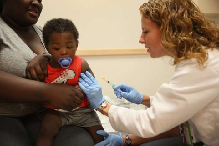 India Ampah holds her son, Keon Lockhart, 12 months old, as Dr. Amanda Porro administers a measles vaccination during a visit to the Miami Children’s Hospital on June 02, 2014, in Miami. (Joe Raedle/Getty Images)