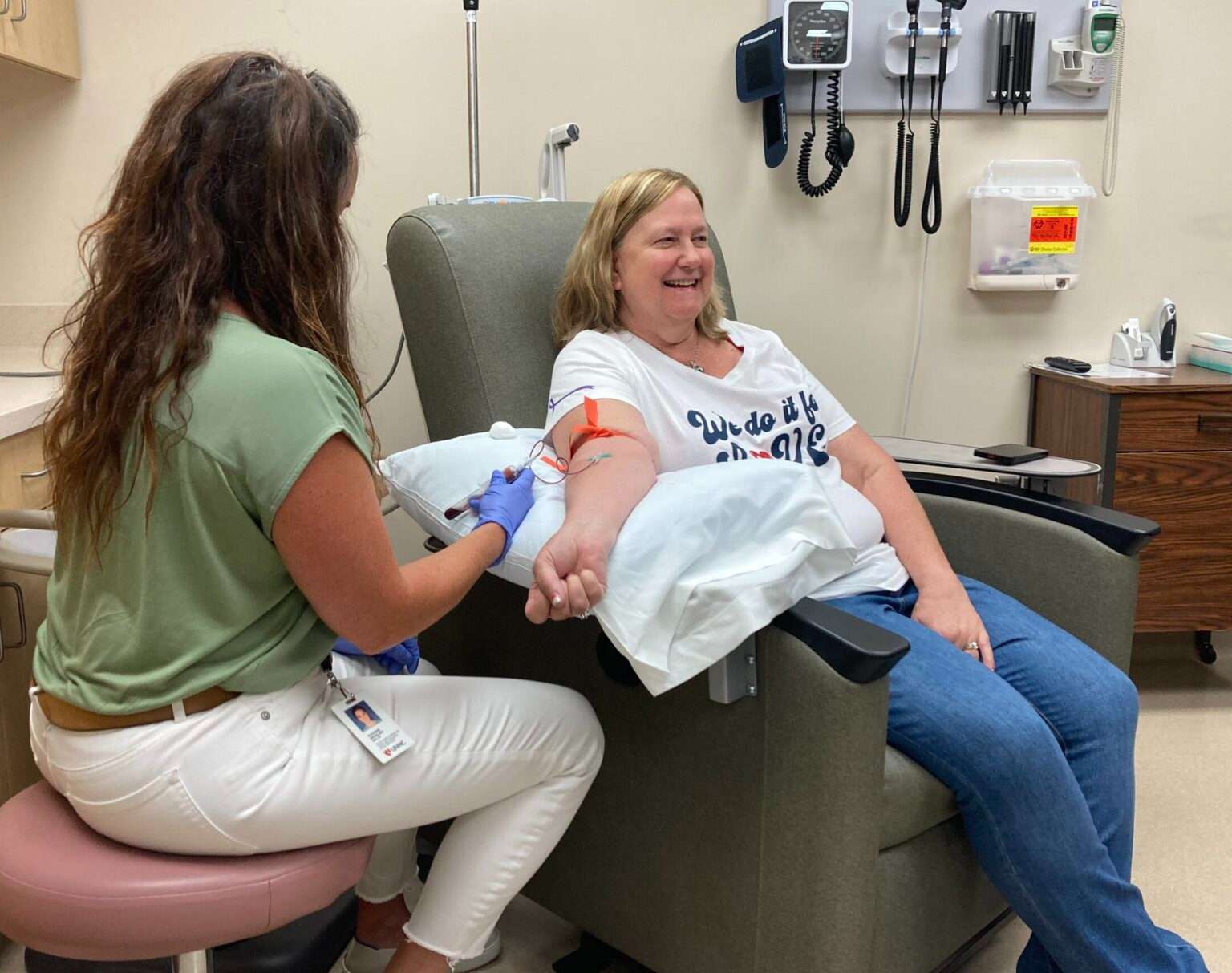 Becky Wright of Montgomery, Illinois, provides blood for a study of pancreatic cancer. Wright qualifies for the study because of a prevalence of the disease in her family. Suzanne Wessling, at left, is the research project coordinator. (Paul Hammel/Nebraska Examiner)
