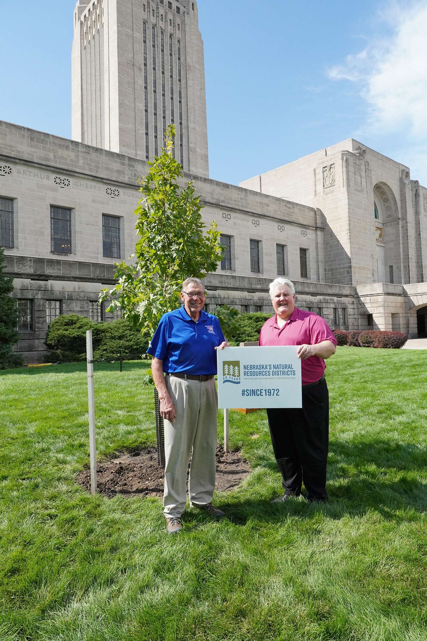 Nebraska Association of Resources Districts President Dr. Orval Gigstad, left, and Executive Travel Chairman Steve Glenn help plant a tree at the Nebraska State Capitol in September 2022. Lincoln-based Executive Travel has taken the initiative to offset its carbon emissions by planting trees throughout the state.