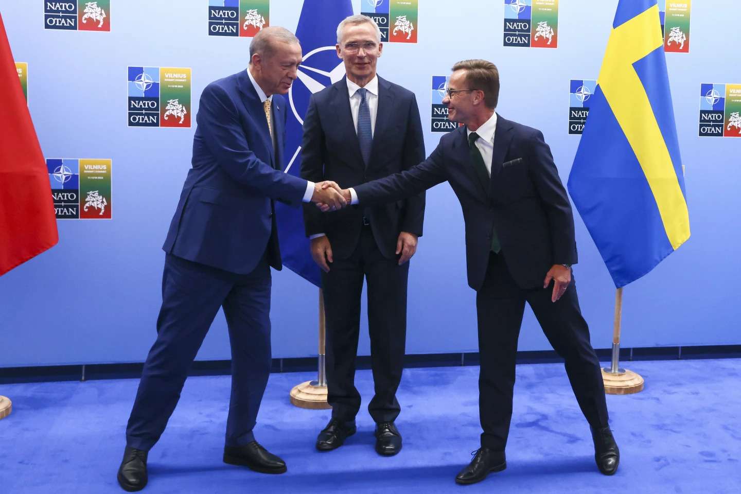 Turkey's President Recap Tayyip Erdogan, left, shakes hands with Sweden's Prime Minister Ulf Kristersson, right, as NATO Secretary General Jens Stoltenberg looks on prior to a meeting ahead of a NATO summit in Vilnius, Lithuania, Monday, July 10, 2023. (Yves Herman, Pool Photo via AP)ASSIOCATED PRESS