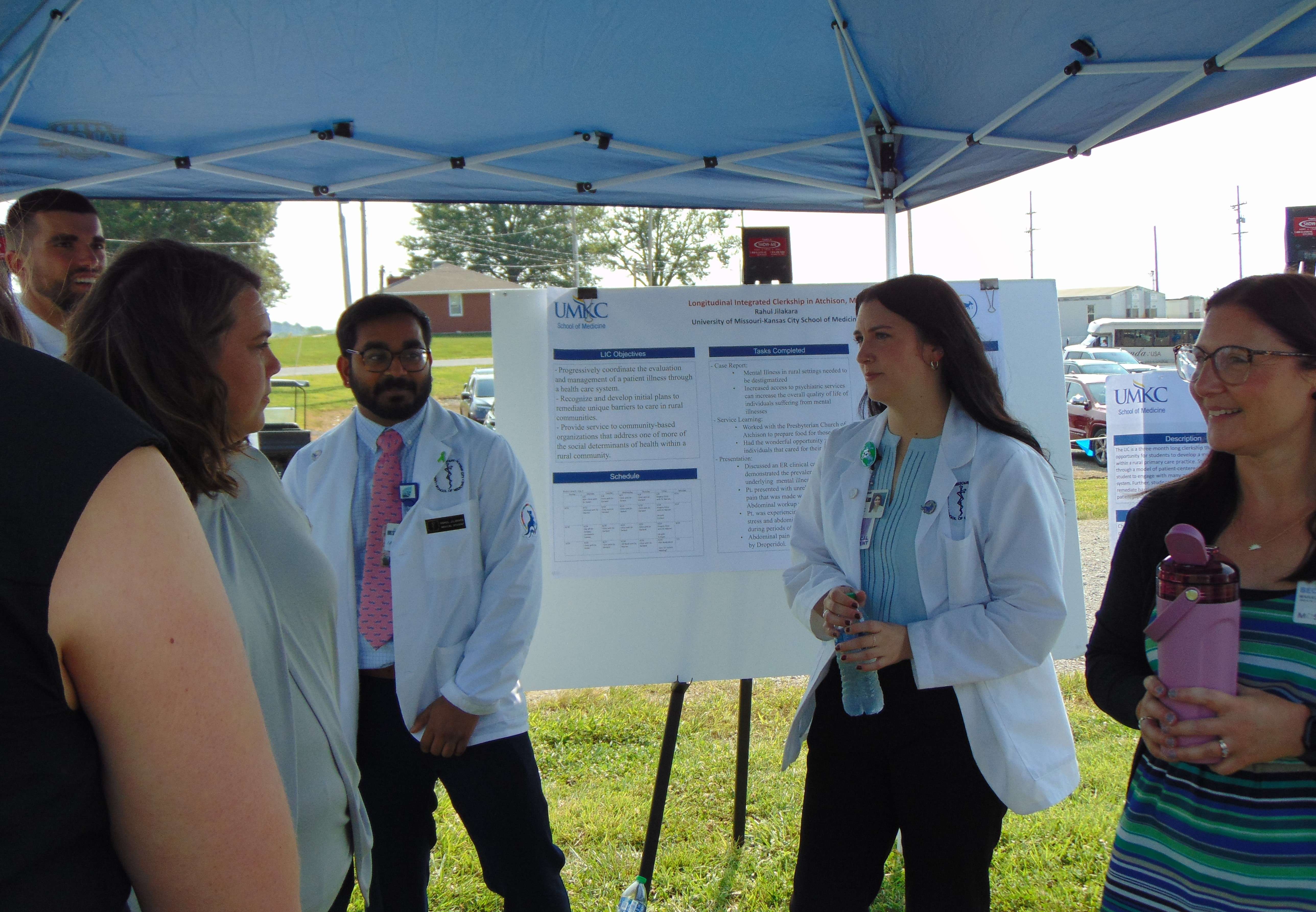 UMKC medical student Emma Smith (right, in lab coat) talks with fellow students during the groundbreaking ceremony/Photo by Brent Martin