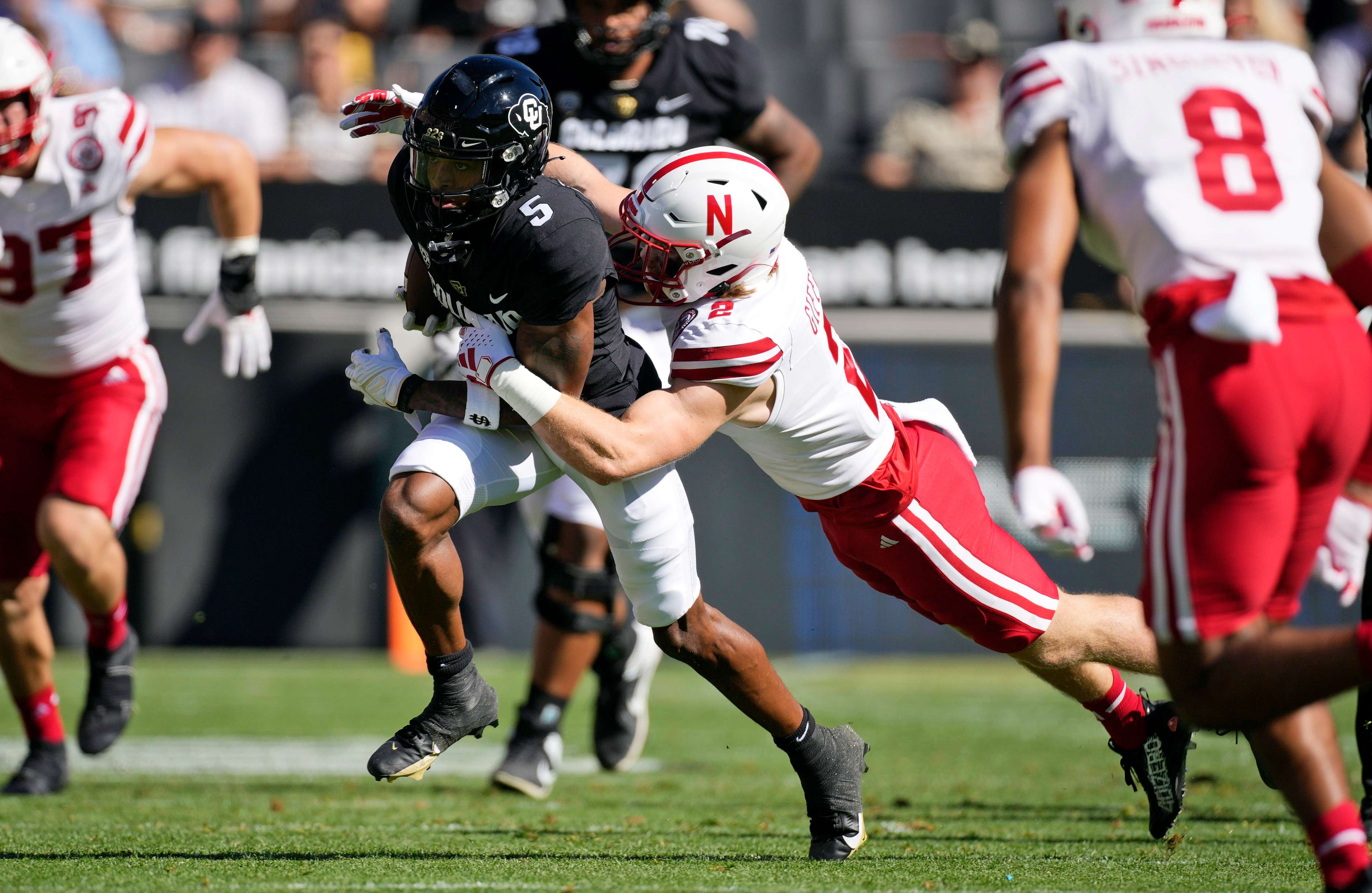 Colorado wide receiver Jimmy Horn Jr., left, is pulled down after a short gain by Nebraska defensive back Isaac Gifford in the first half of an NCAA college football game Saturday, Sept. 9, 2023, in Boulder, Colo. (AP Photo/David Zalubowski)