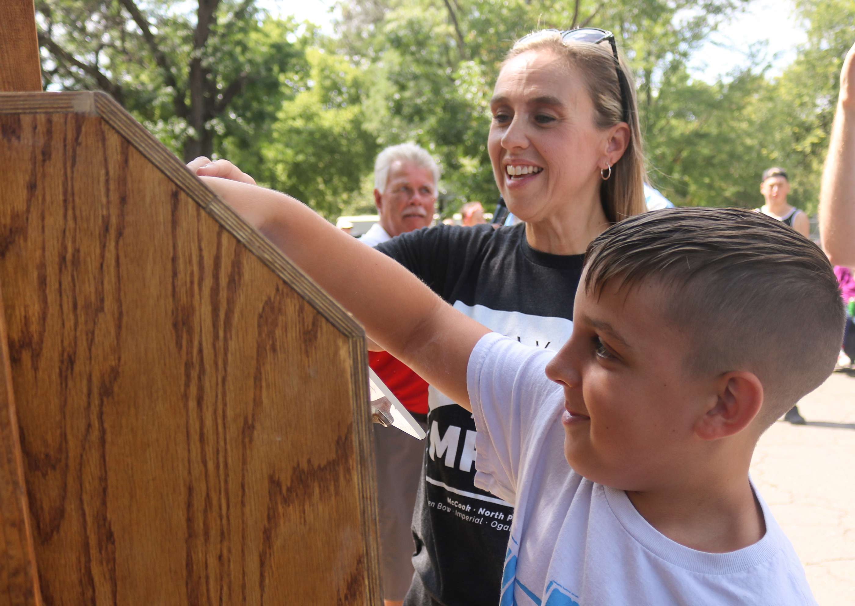 Konnor Knapp assists Dr. Jody Tomanek, vice president of academic affairs and North Platte Community College, with drawing the winning ticket for the 1972 Pontiac Le Mans Sport at the Colonel Cody’s Cruise Show and Shine in Memorial Park on Saturday.