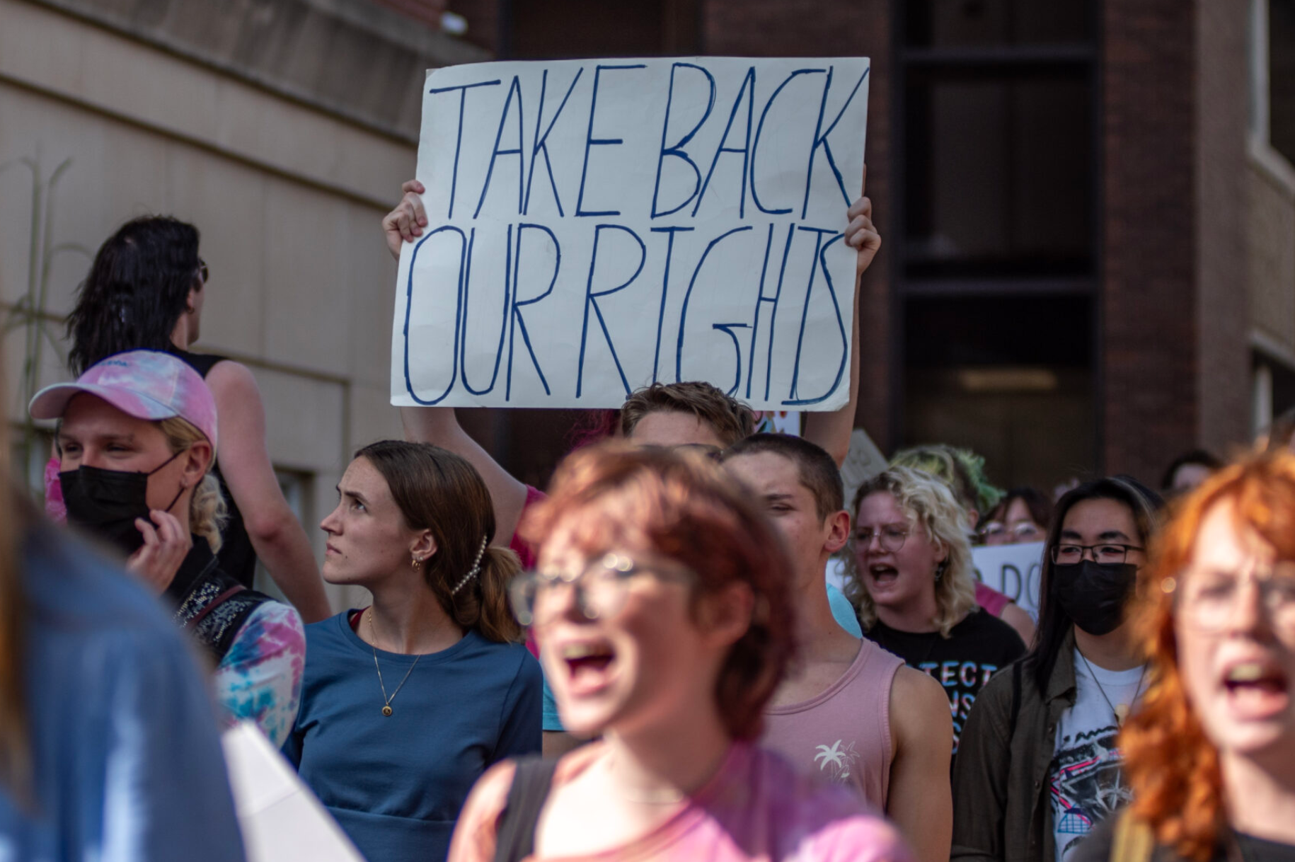 A group protesting MU Health's cancelation of transgender minors' prescriptions chants as it walks toward Columbia City Hall (Annelise Hanshaw/Missouri Independent).