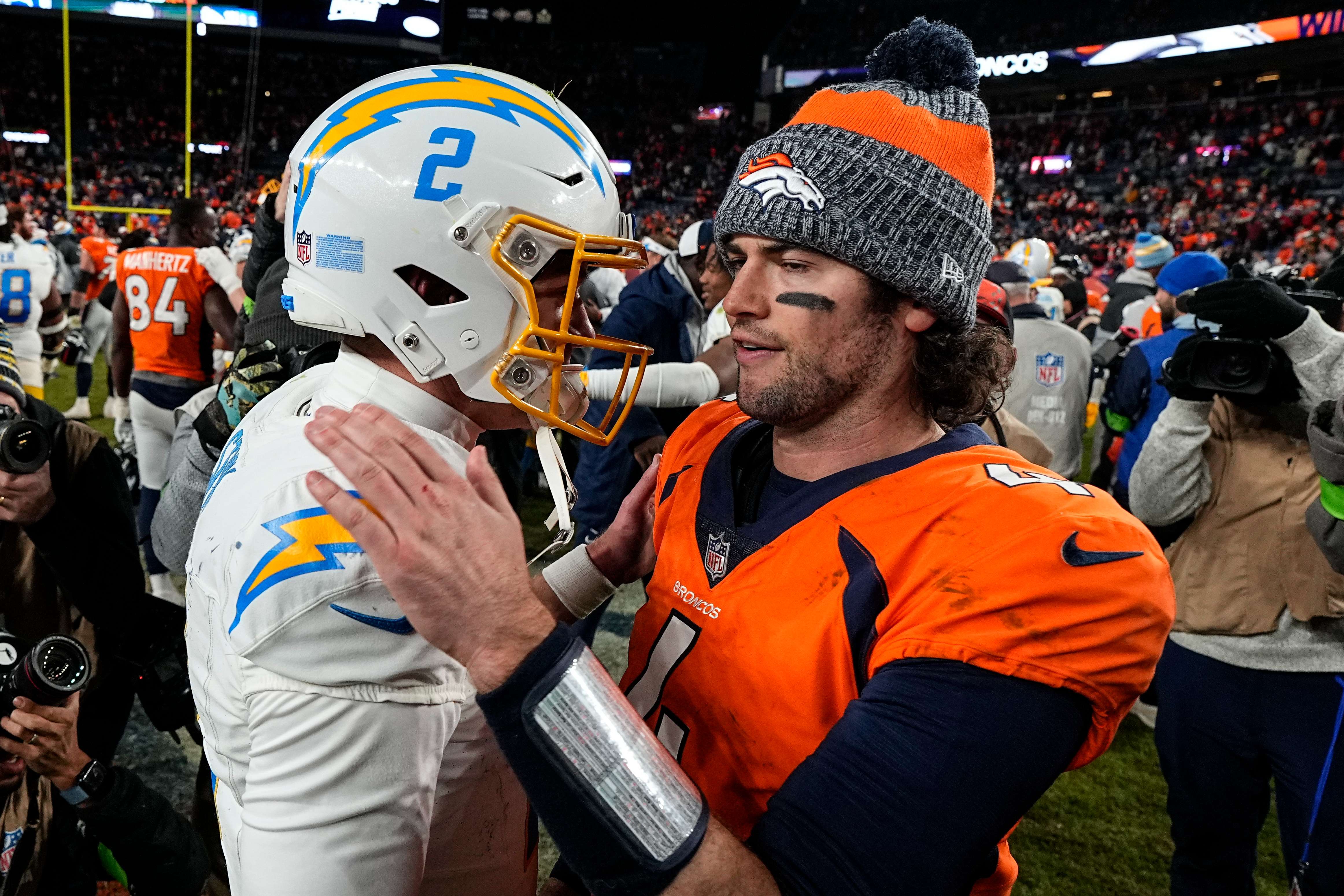 Los Angeles Chargers quarterback Easton Stick (2) and Los Angeles Chargers quarterback Will Grier (4) speak midfield after an NFL football game, Sunday, Dec. 31, 2023, in Denver. The Denver Broncos won 16-9. (AP Photo/Jack Dempsey)
